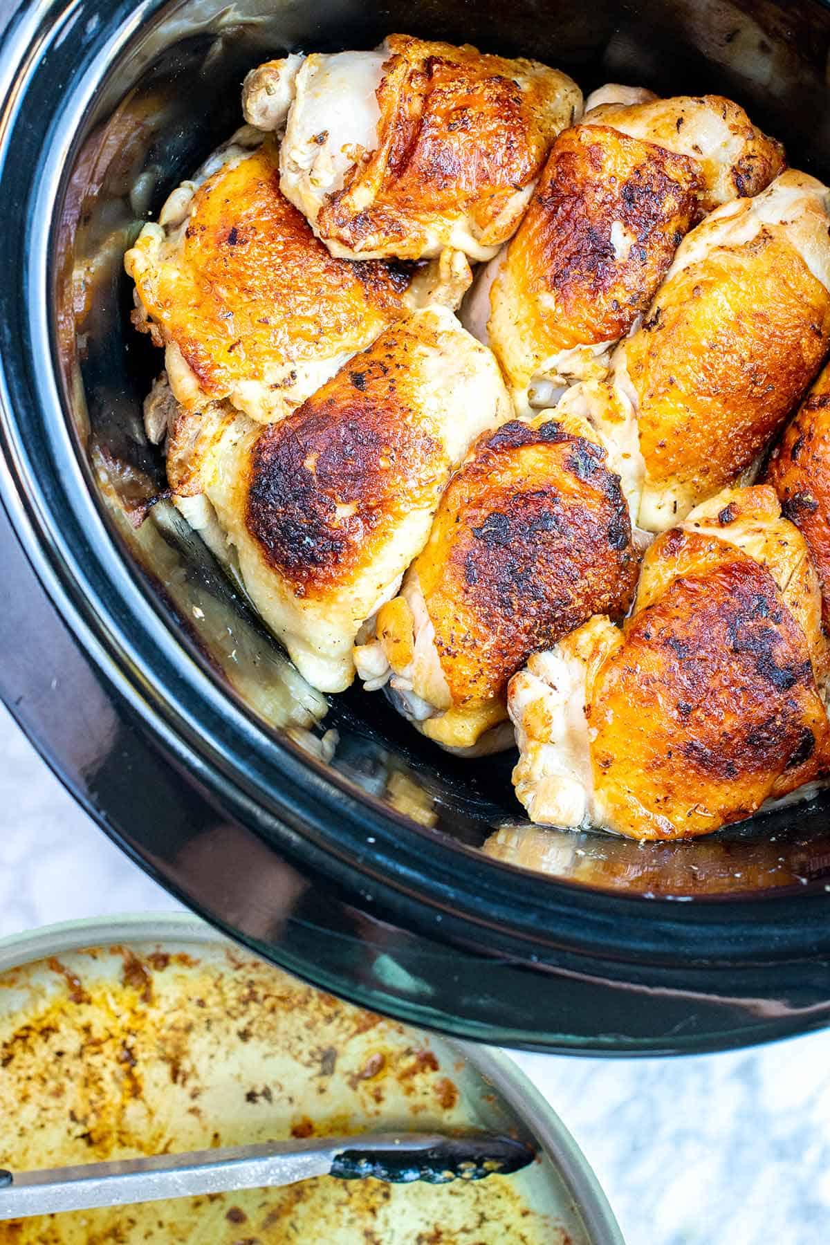 Chicken thighs in a slow cooker -- the chicken was browned in a skillet first, and then added to the slow cooker.