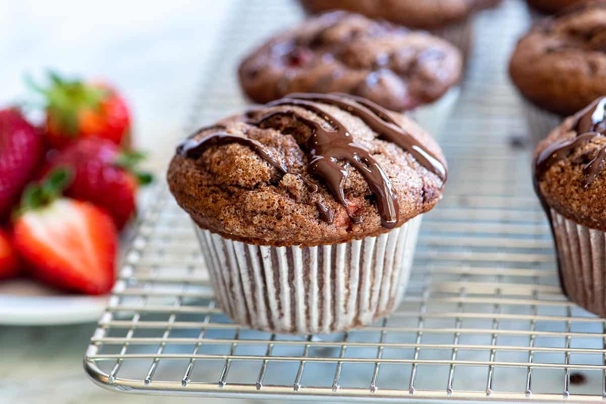 This easy chocolate muffins recipe combines two of our favorite things: fresh strawberries and chocolate! See how to make tender muffins packed with strawberries and topped with a chocolate drizzle.