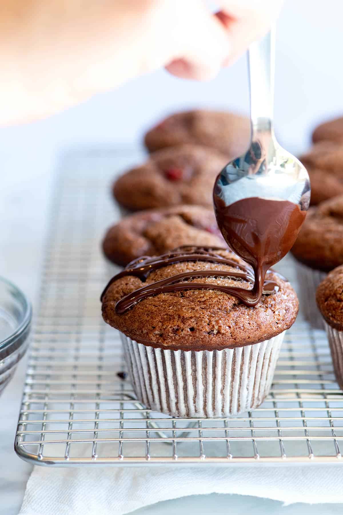 This easy chocolate muffins recipe combines two of our favorite things: fresh strawberries and chocolate! How to Make Strawberry Chocolate Muffins: Drizzling chocolate over the baked muffins
