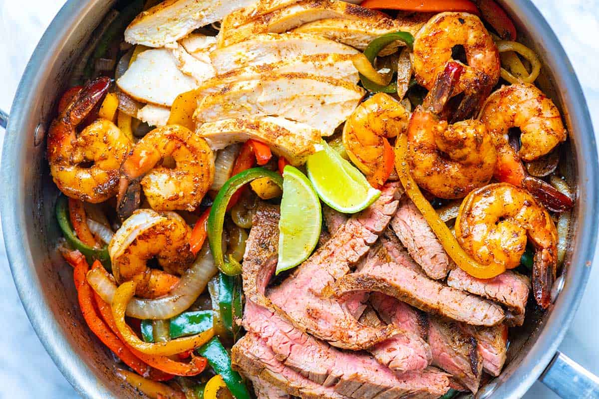 A skillet of the Best Fajitas with Chicken, Steak, Shrimp and Veggies