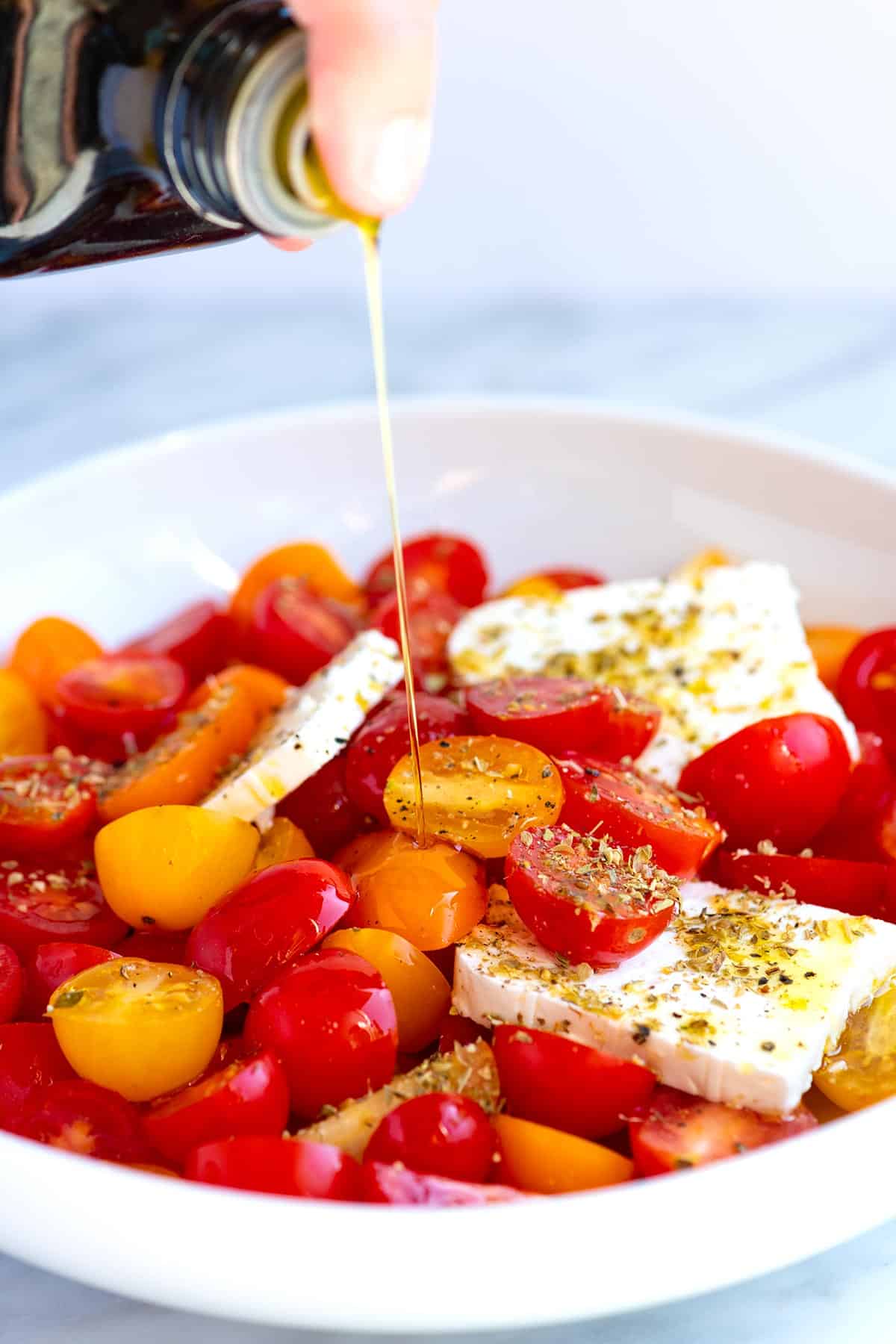 Drizzling Olive Oil over Cherry Tomato Salad