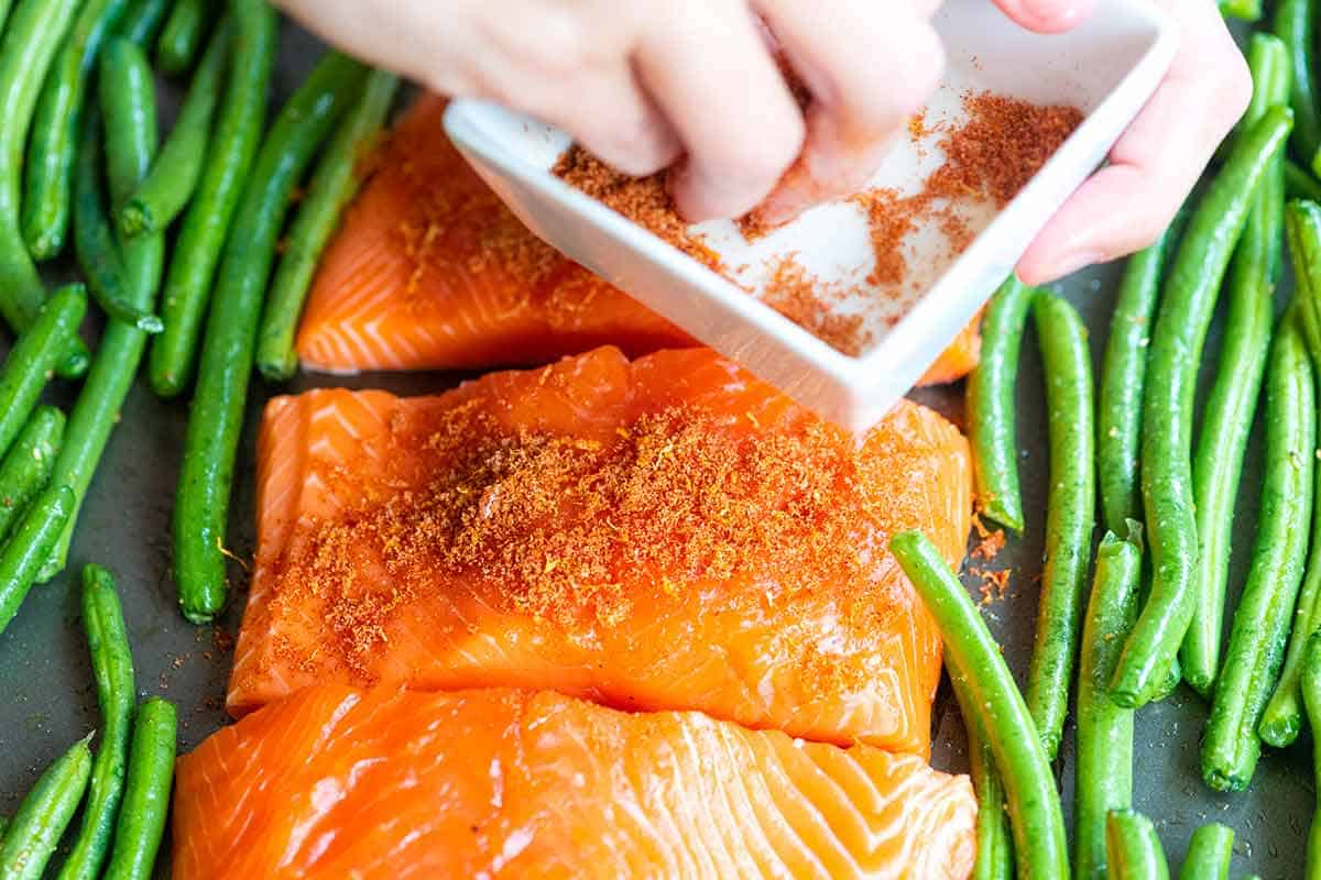 Adding Brown sugar spice rub to salmon fillets