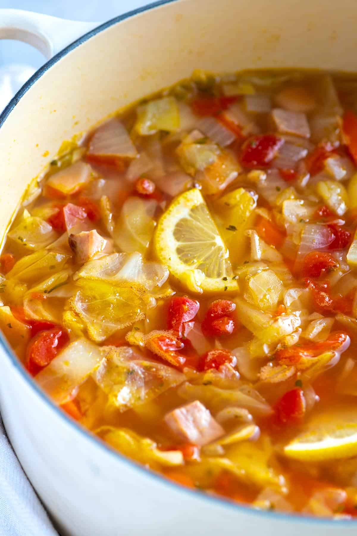 Cabbage soup with ham, tomatoes and lemon