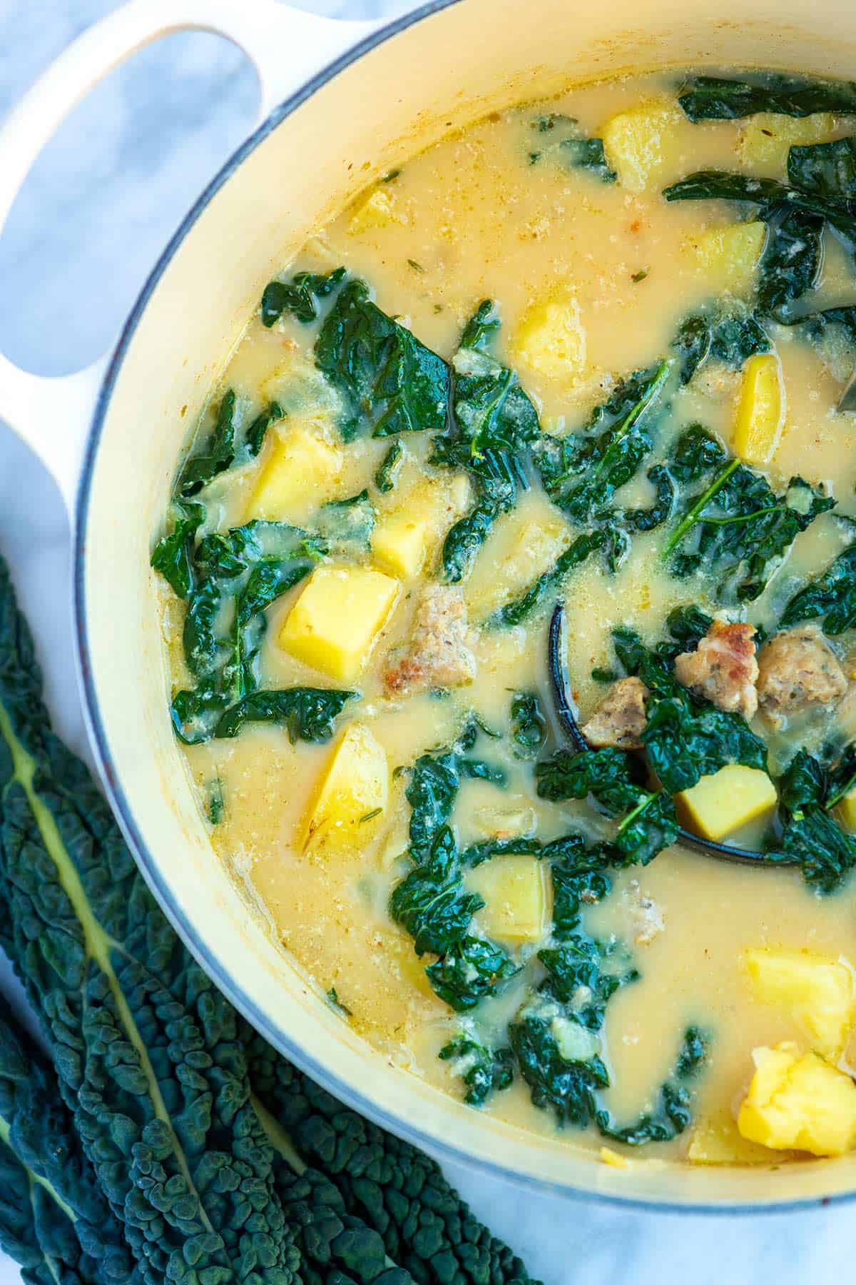 A pot of potato soup with sausage and kale