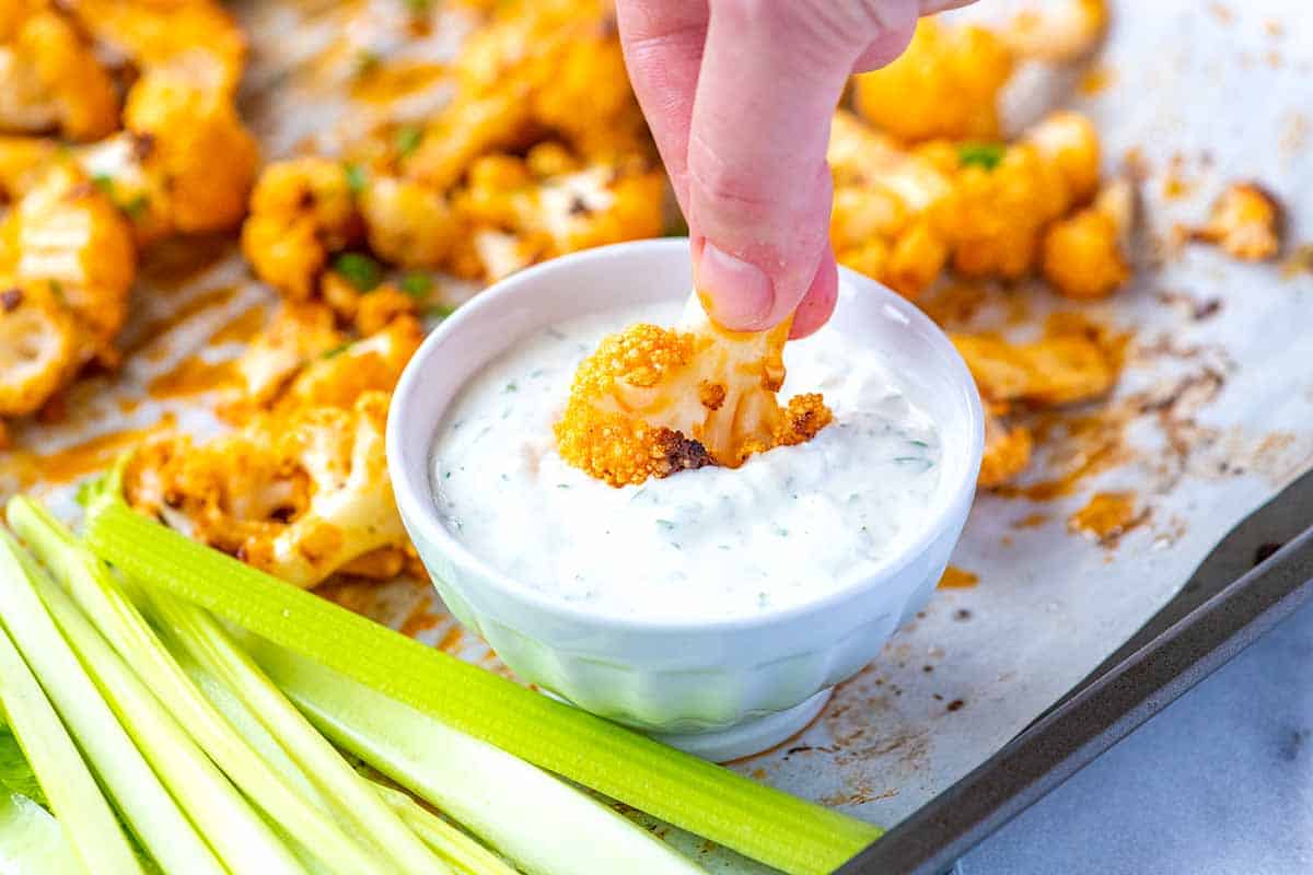 Cauliflower Wings: Dipping a buffalo cauliflower wing into blue cheese dressing