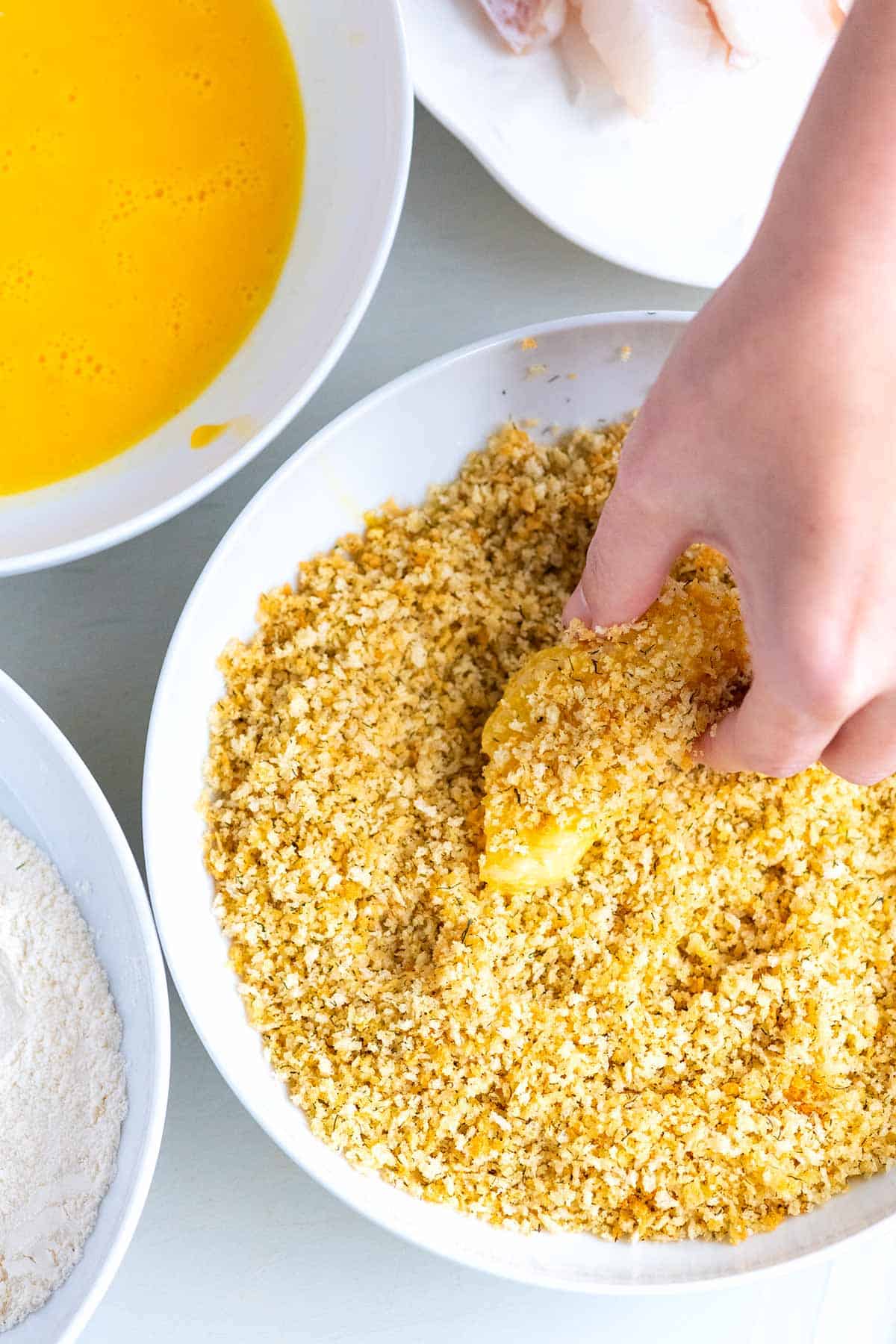 Breading fish sticks with flour, egg and breadcrumbs