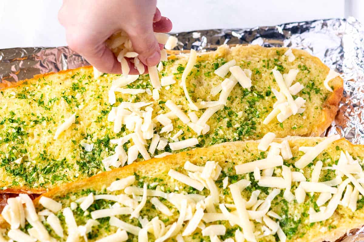 Adding cheese to garlic bread