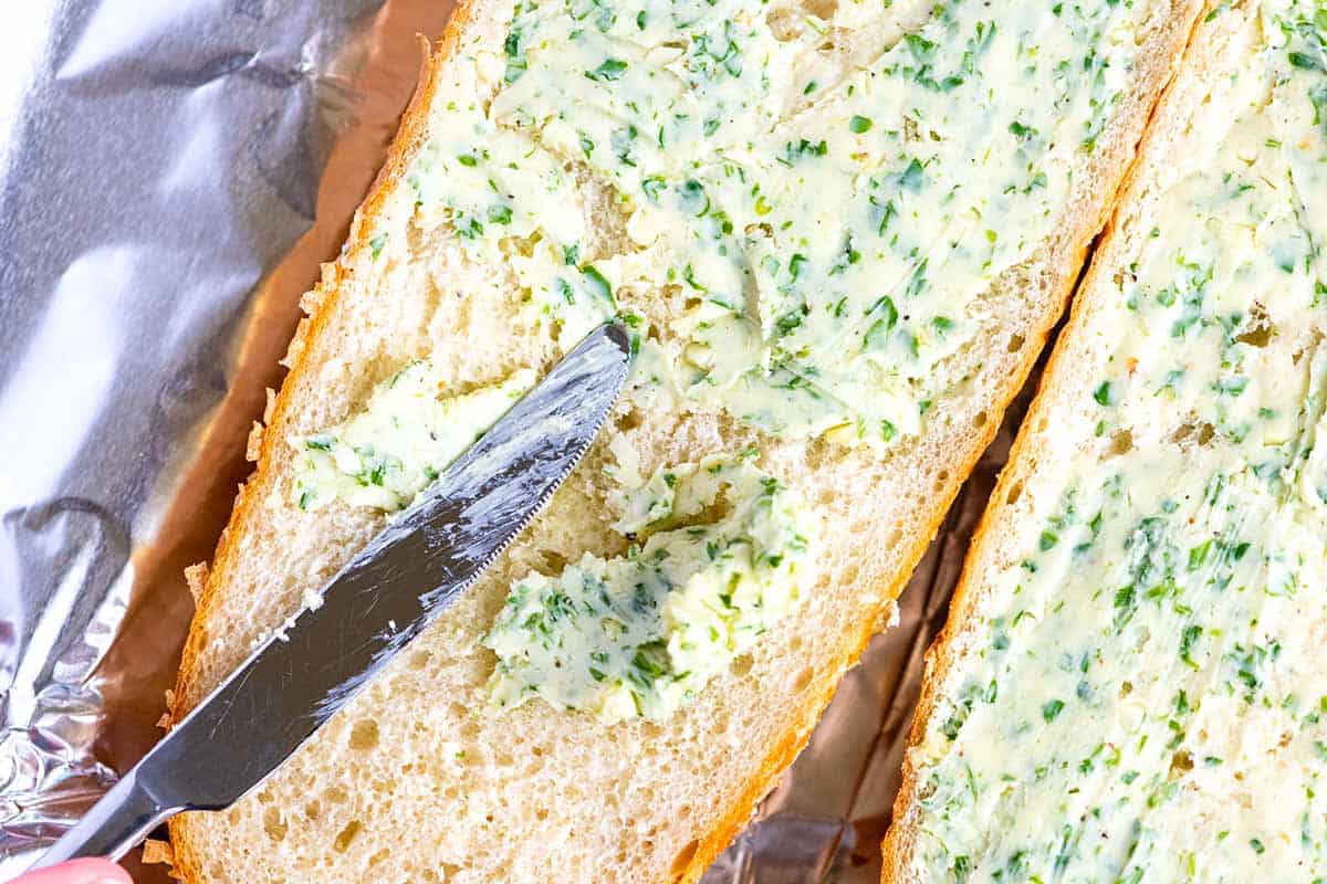How to Make Garlic Bread: Spreading garlic butter over bread