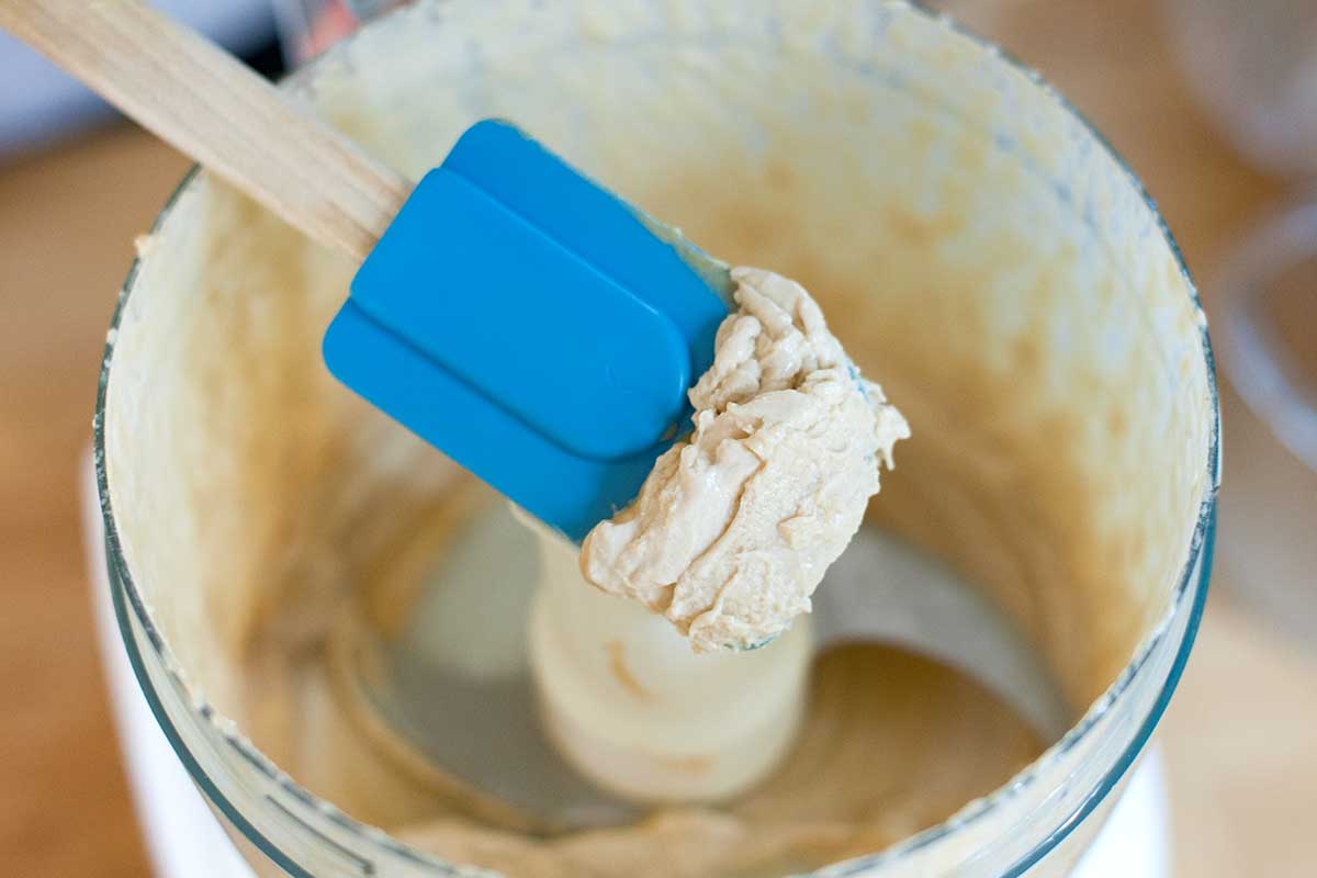 Here's what the lemon and tahini looks like after a minute of processing, the tahini and lemon juice turns into a thick, whipped paste. It's this whipped tahini paste that makes for the best hummus.