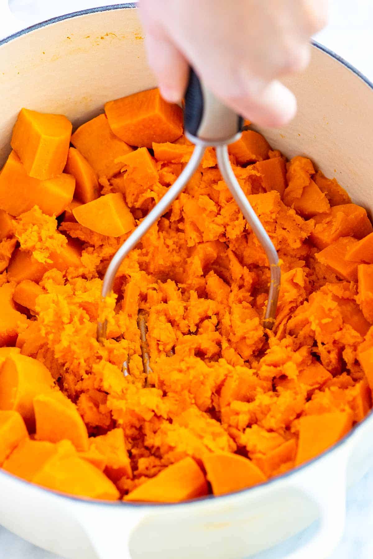 Mashing sweet potatoes with a potato masher