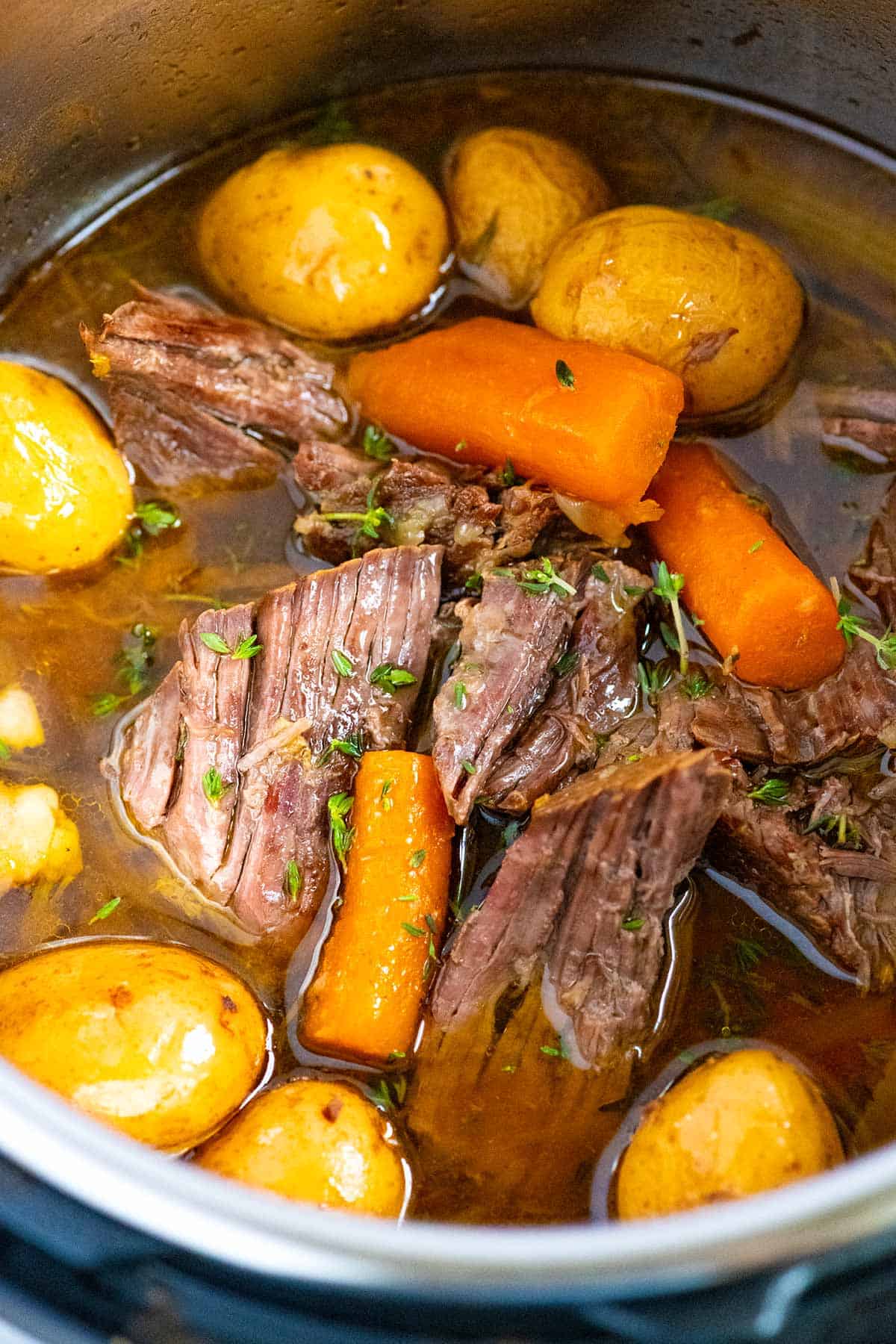 Close-up of fork-tender Instant Pot pot roast with carrots and potatoes.