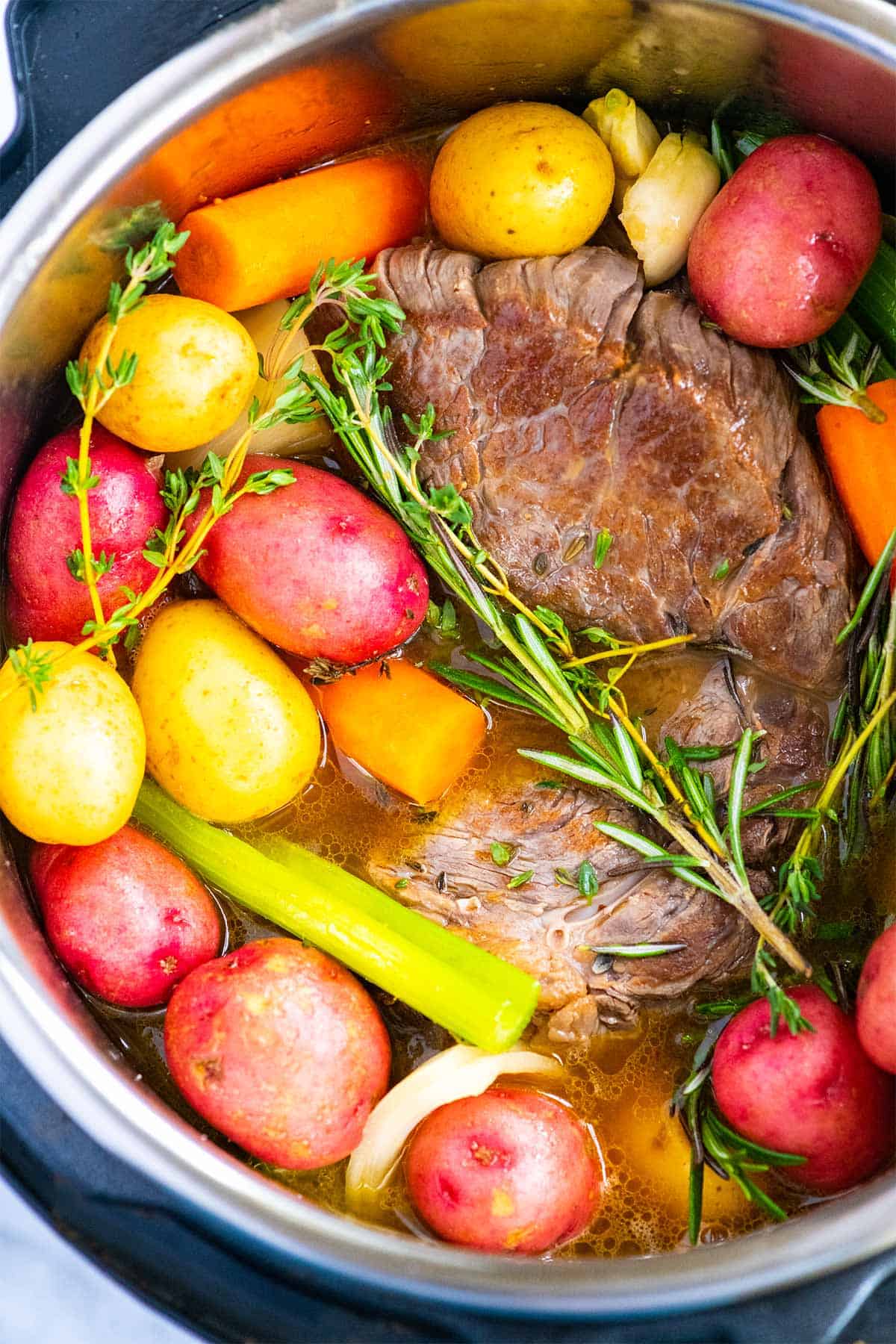 Seared beef with rosemary, thyme, and carrots ready for the Instant Pot