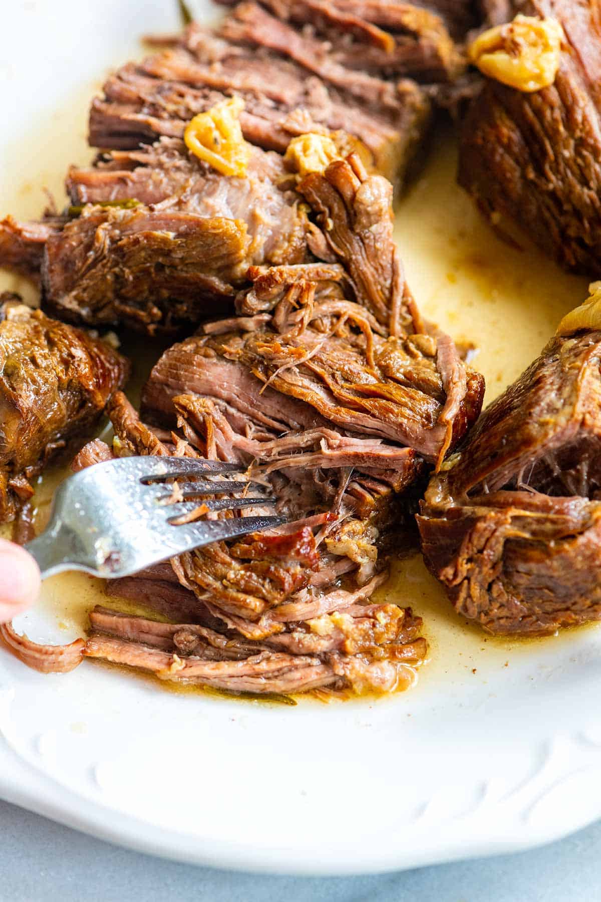 Fork pulling apart incredibly tender Instant Pot pot roast.