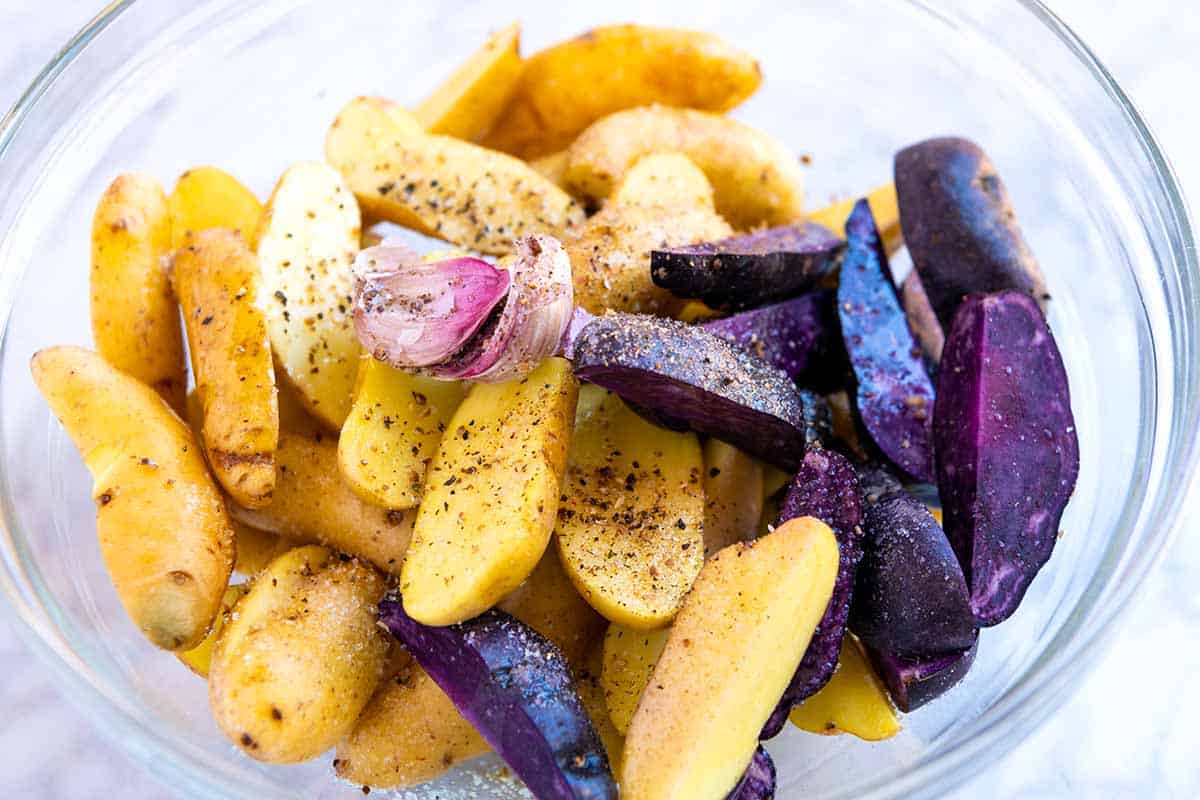 How to Make Roasted Fingerling Potatoes: Tossing the potatoes with salt, pepper, and oil in a bowl first ensures that every potato is well seasoned.