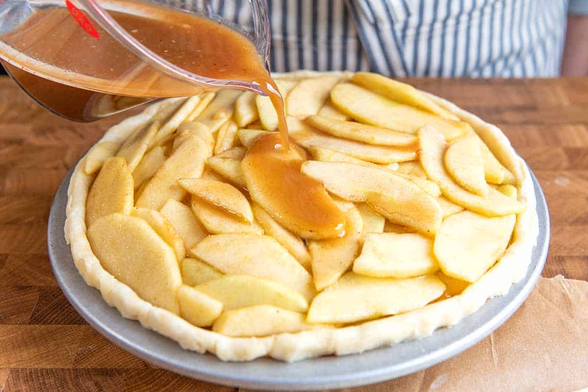 Adding apple pie filling to the pie crust.