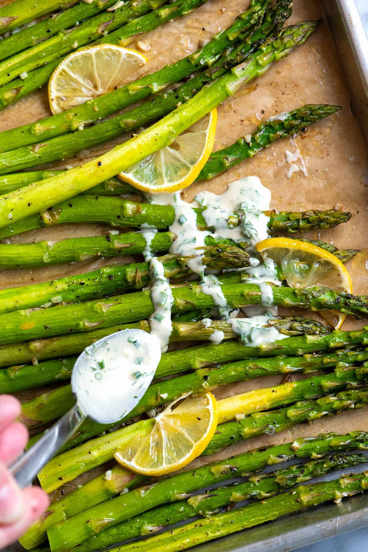 This roasted asparagus is a simple, fast side dish. The asparagus is perfectly tender with slightly crispy tips.  Served with our five minute garlic herb sauce, it's deliciously garlicky, fresh, and vegetarian.