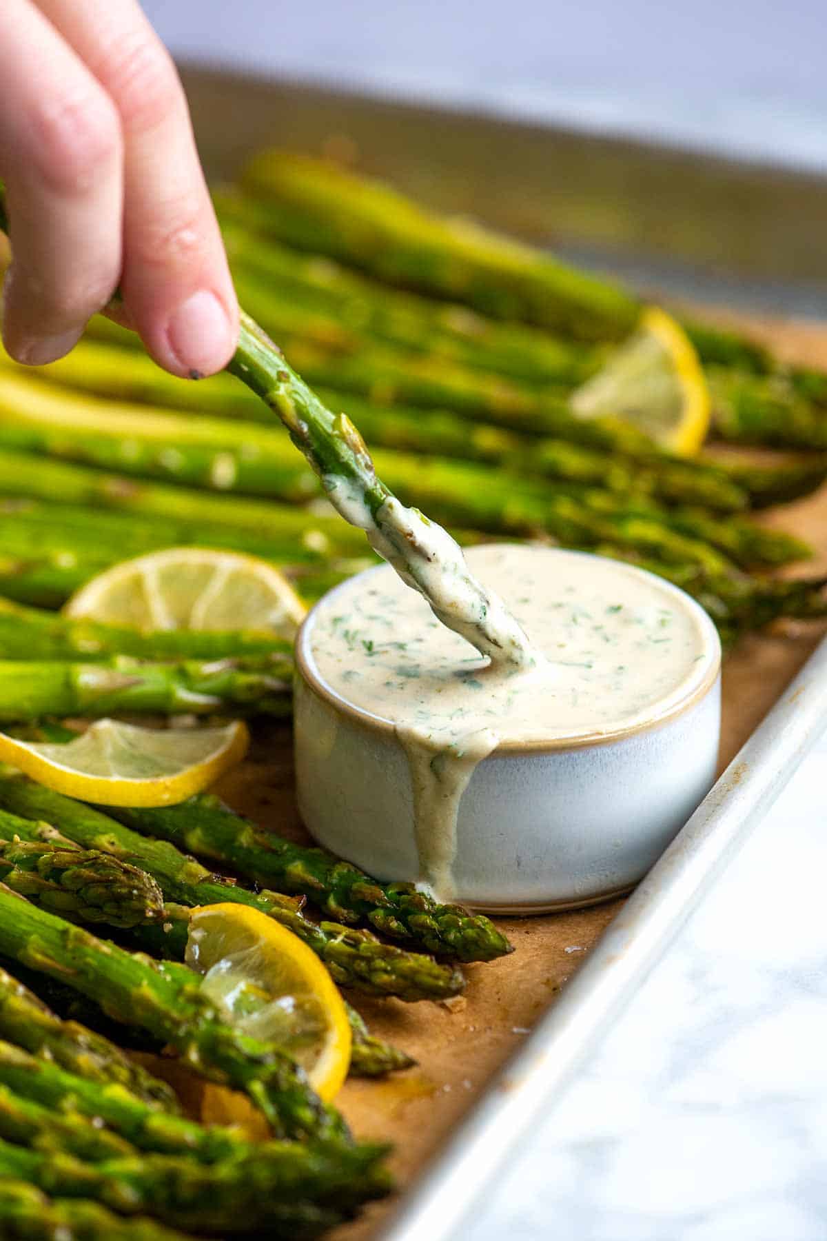This roasted asparagus is a simple, fast side dish. The asparagus is perfectly tender with slightly crispy tips.  Served with our five minute garlic herb sauce, it's deliciously garlicky, fresh, and vegetarian.