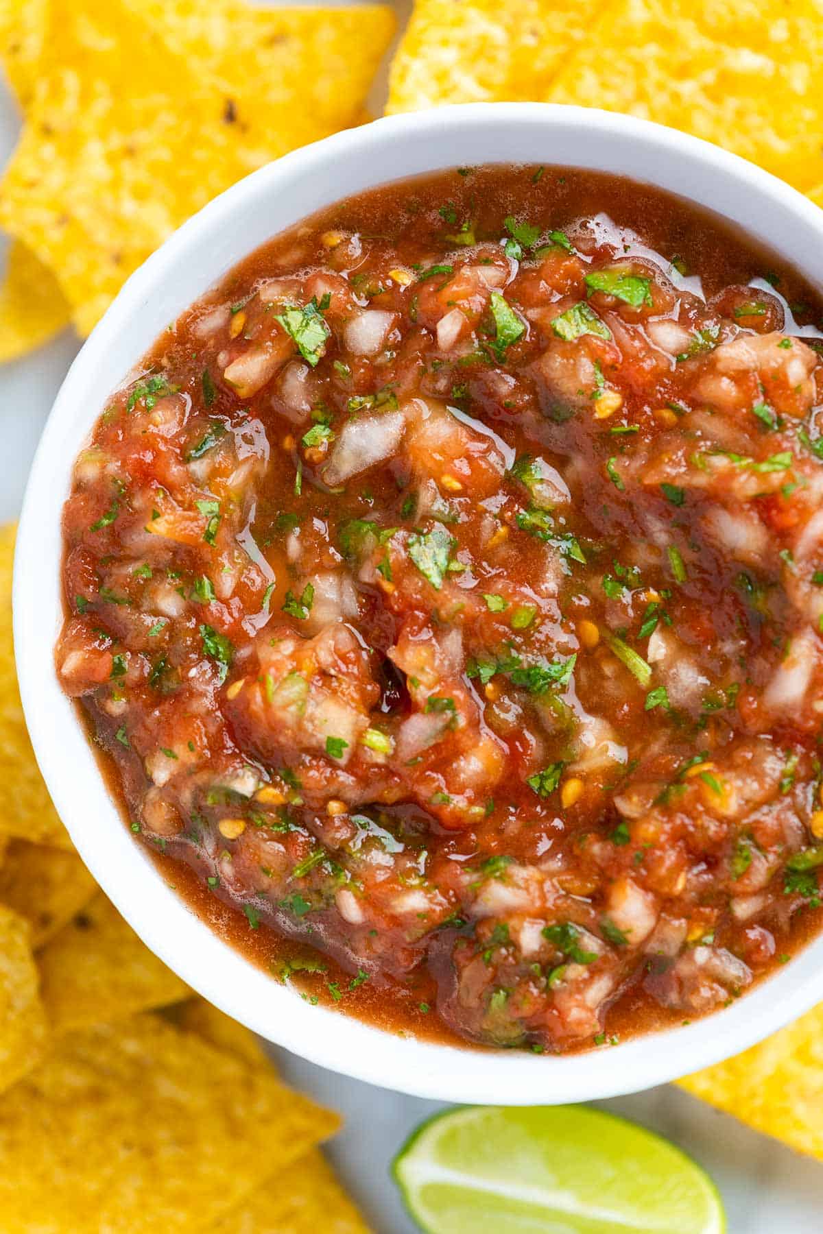 Bowl filled with salsa surrounded with tortilla chips