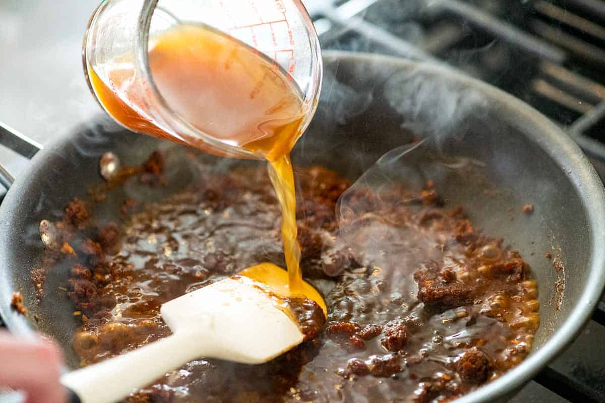 Adding broth to the spices to make enchilada sauce