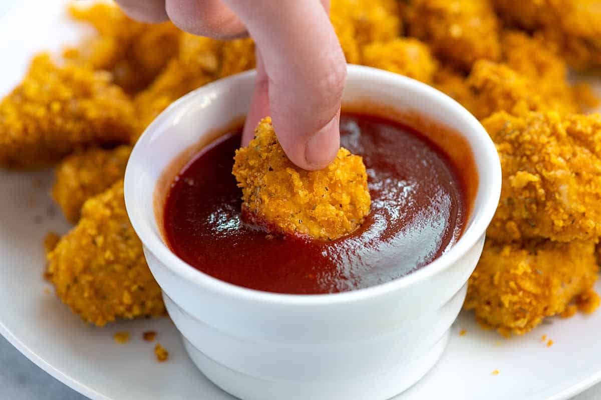 Dipping Homemade Popcorn Chicken into ketchup