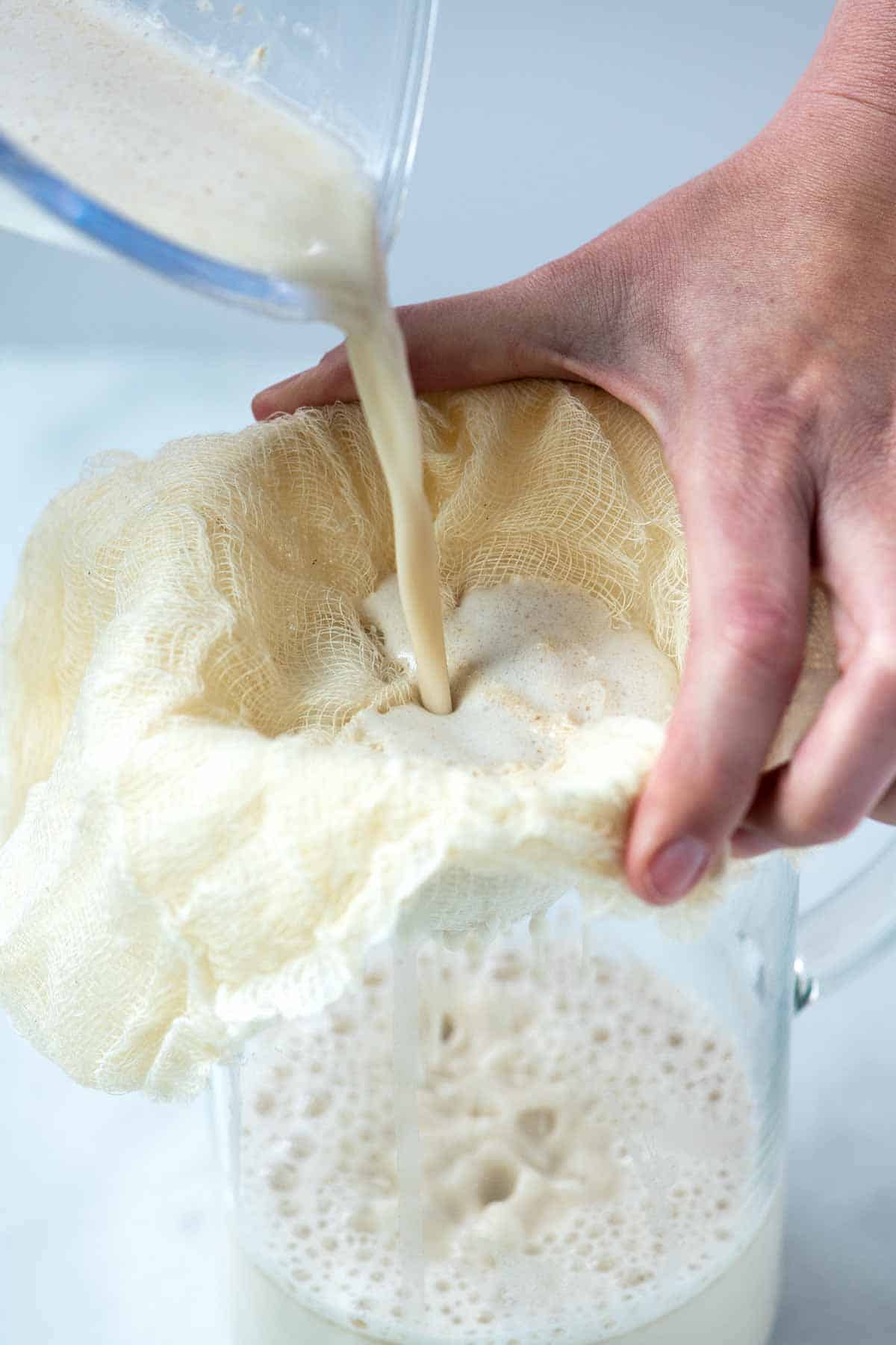 Straining homemade oat milk.