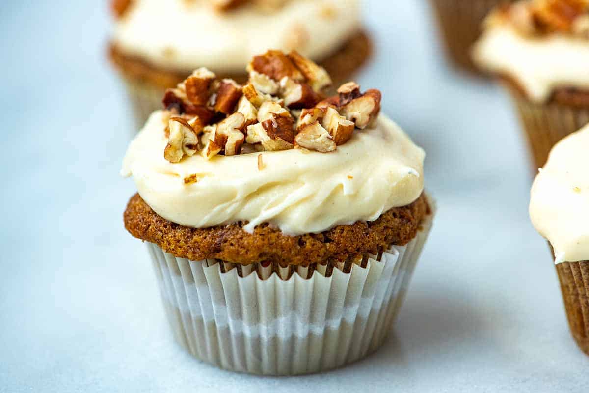 Carrot cake cupcakes with cream cheese frosting and pecans on top