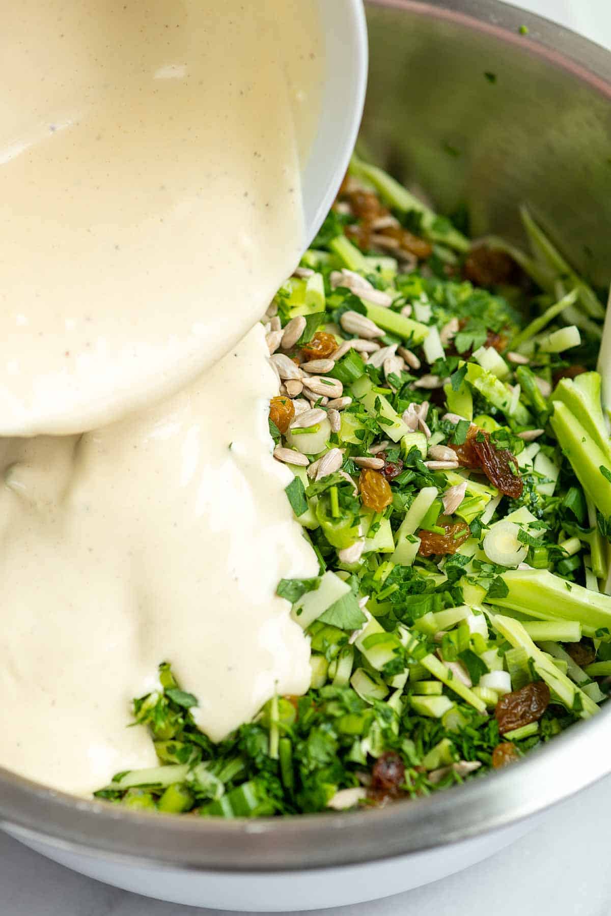 Adding a creamy dressing to broccoli slaw ingredients