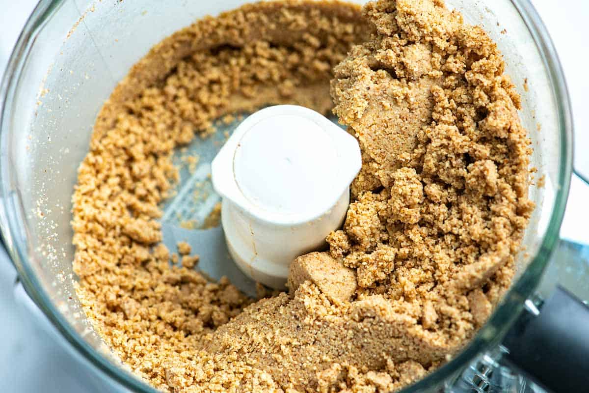 A process shot of making almond butter. Before it turns creamy, it looks like a clumpy mess.