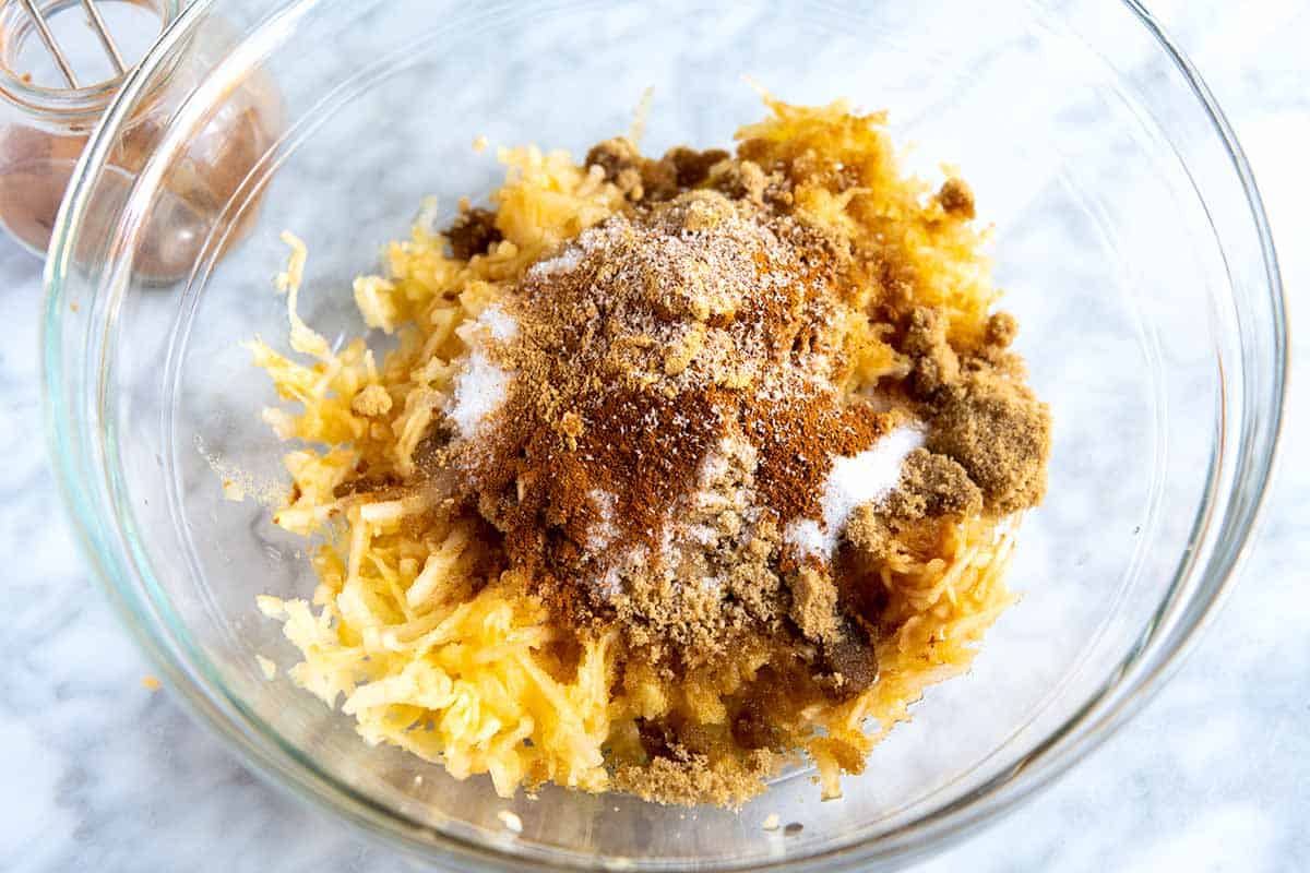 Making apple bread: A bowl with shredded apple, sugar and spices.