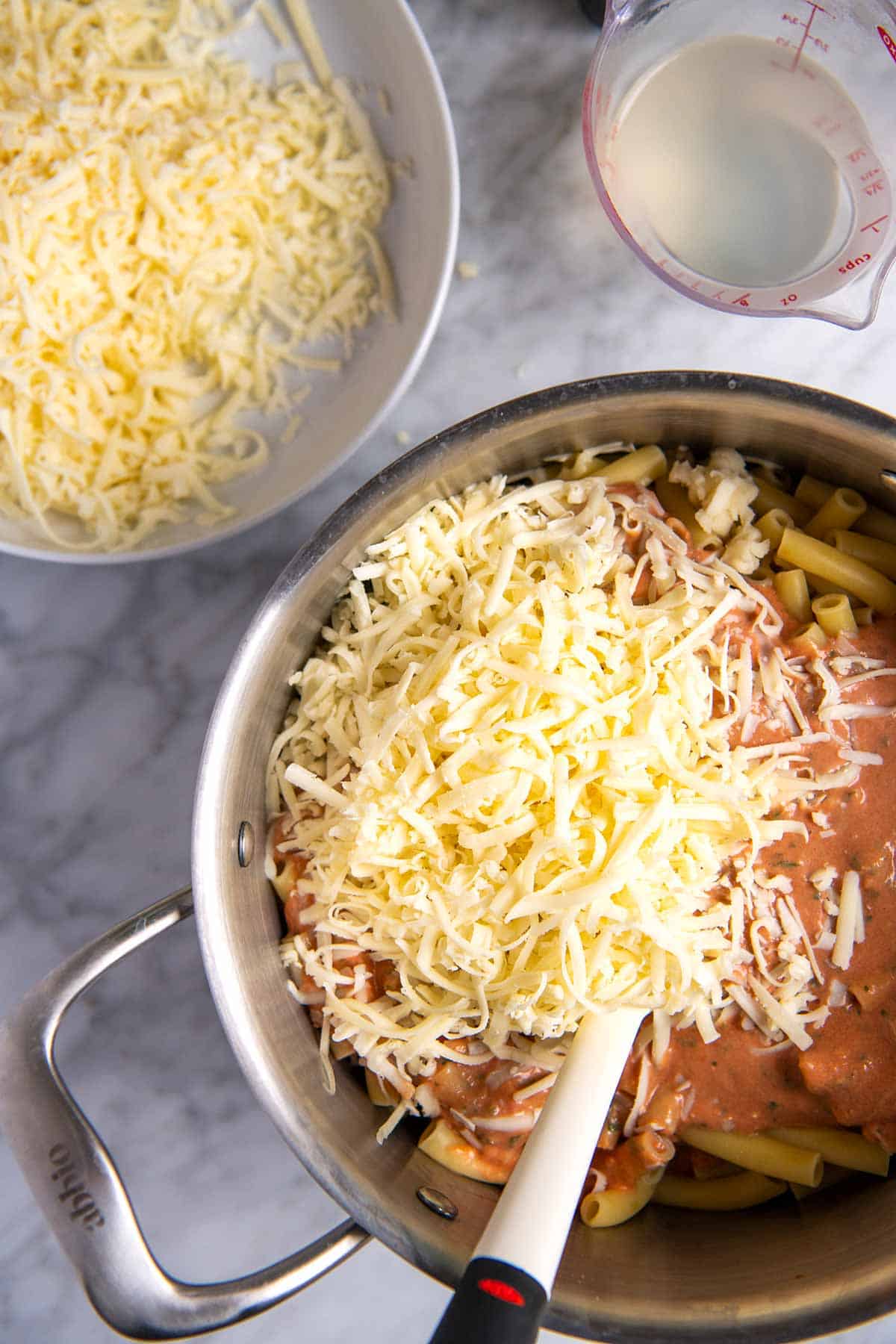 Making baked ziti with sauce, pasta and cheese