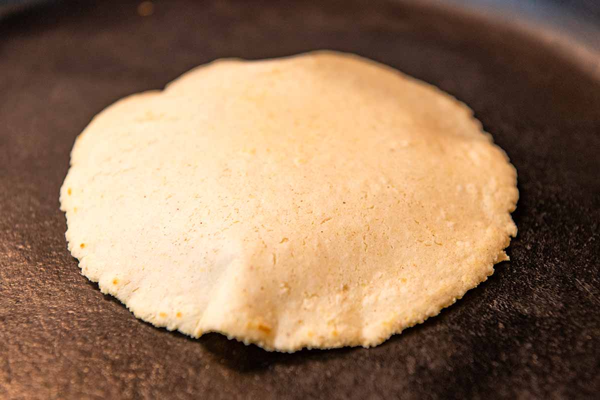 Cooking corn tortillas in a hot skillet.