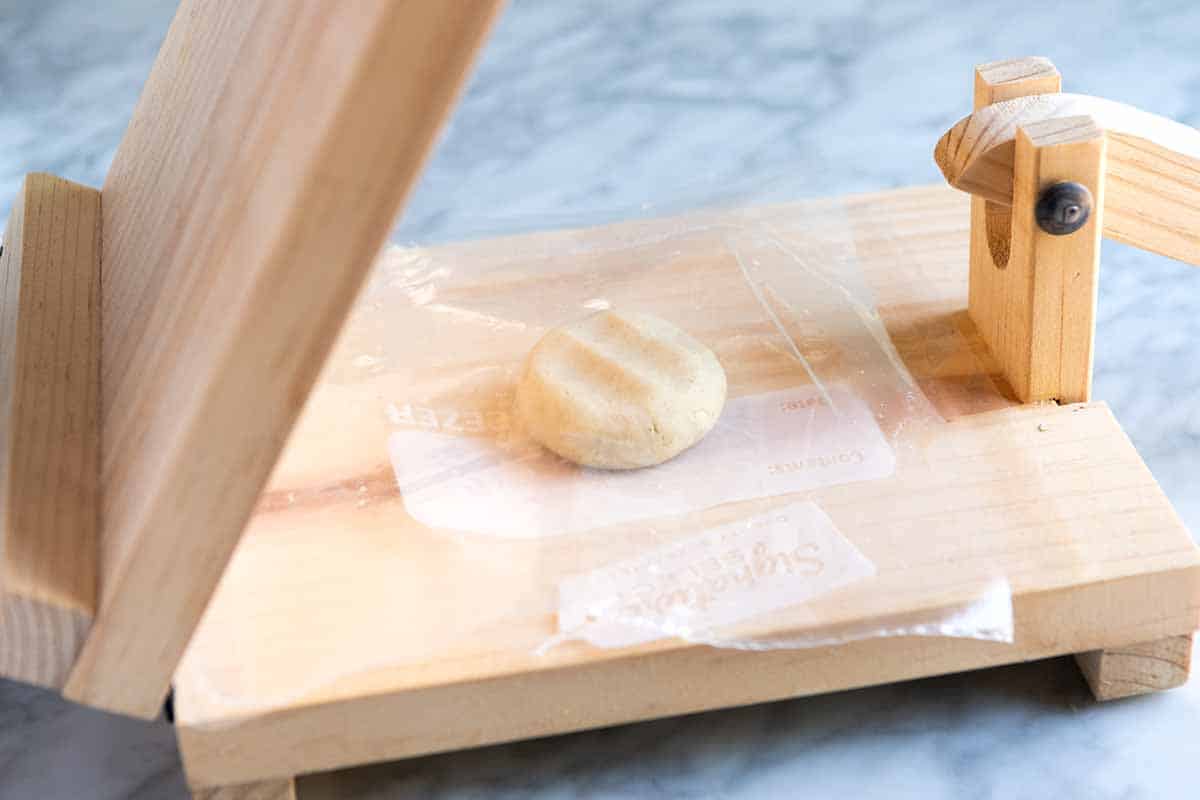 How to Make Corn Tortillas: Pressing masa dough into tortillas, step 1 (add ball of dough to the middle of the press).