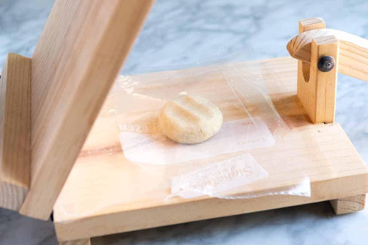 Pressing masa dough into tortillas, step 1 (add ball of dough to the middle of the press).