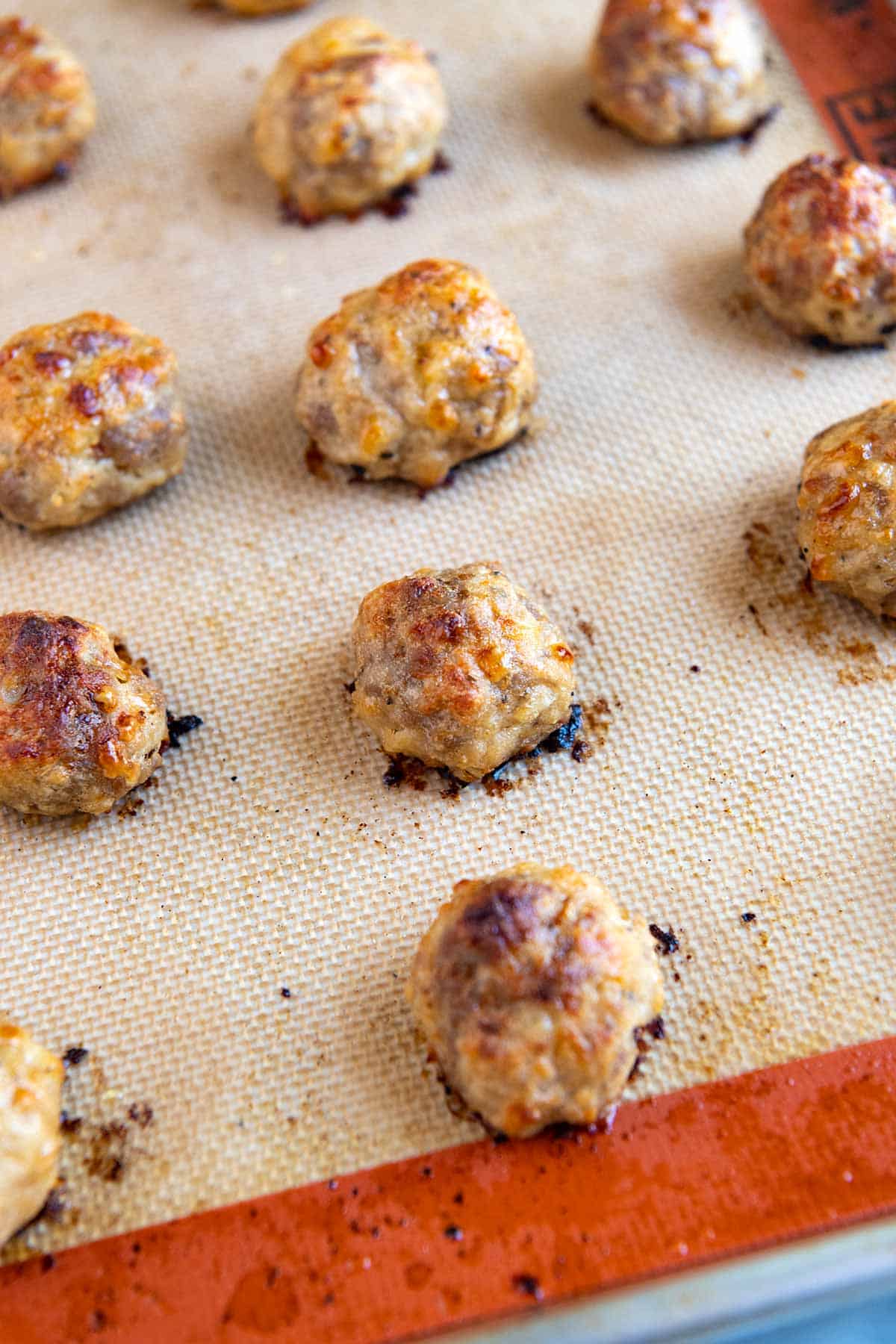 Step shot showing how to make meatballs on a baking sheet in the oven.