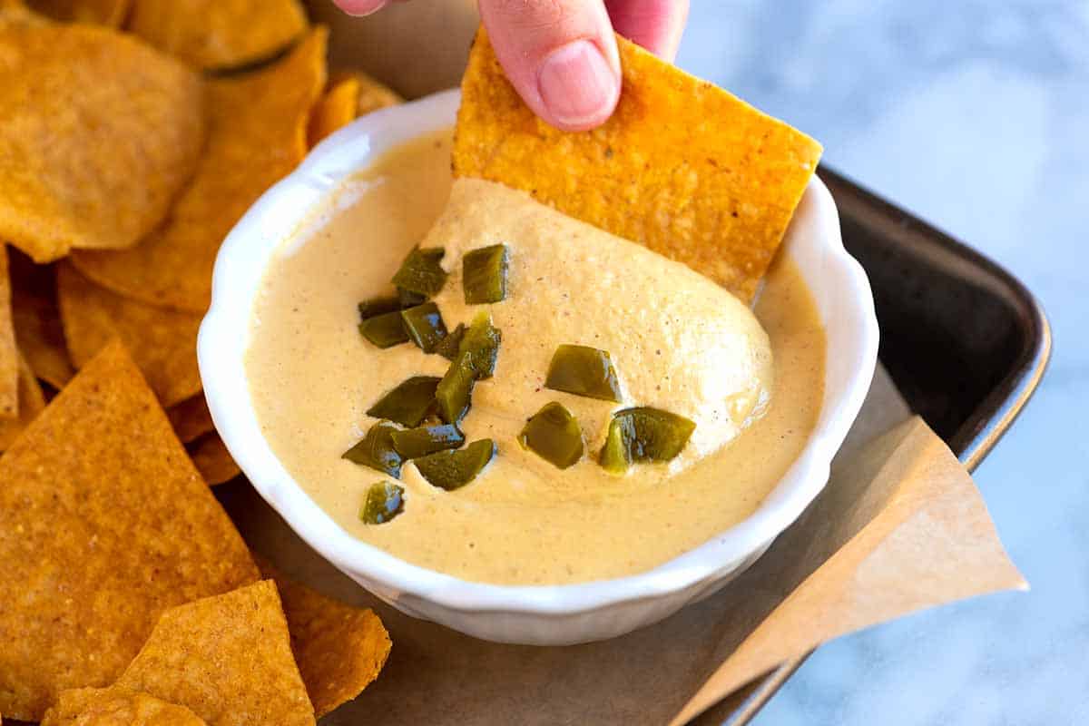 Dipping a chip into Vegan Queso