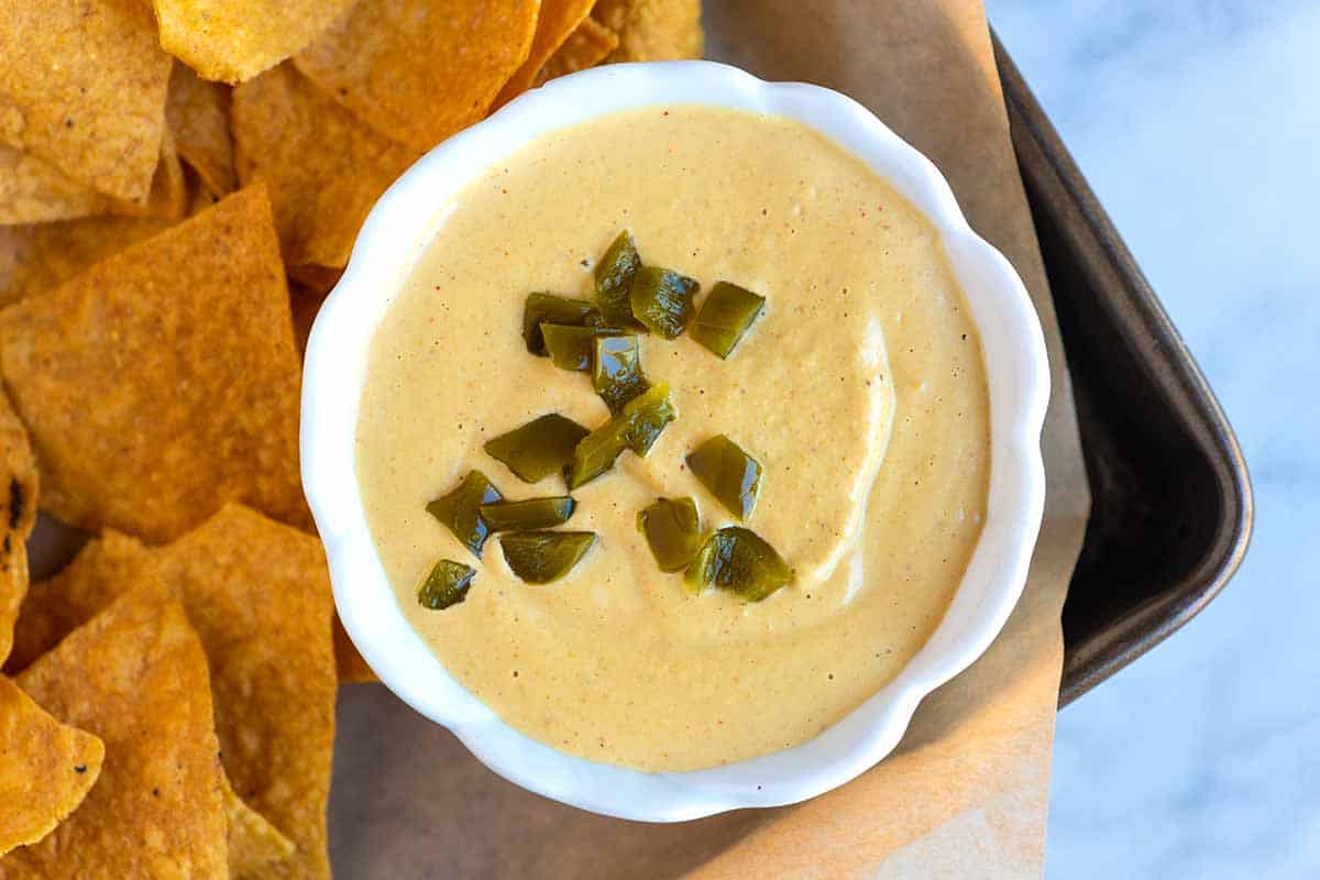 A bowl of vegan queso with tortilla chips