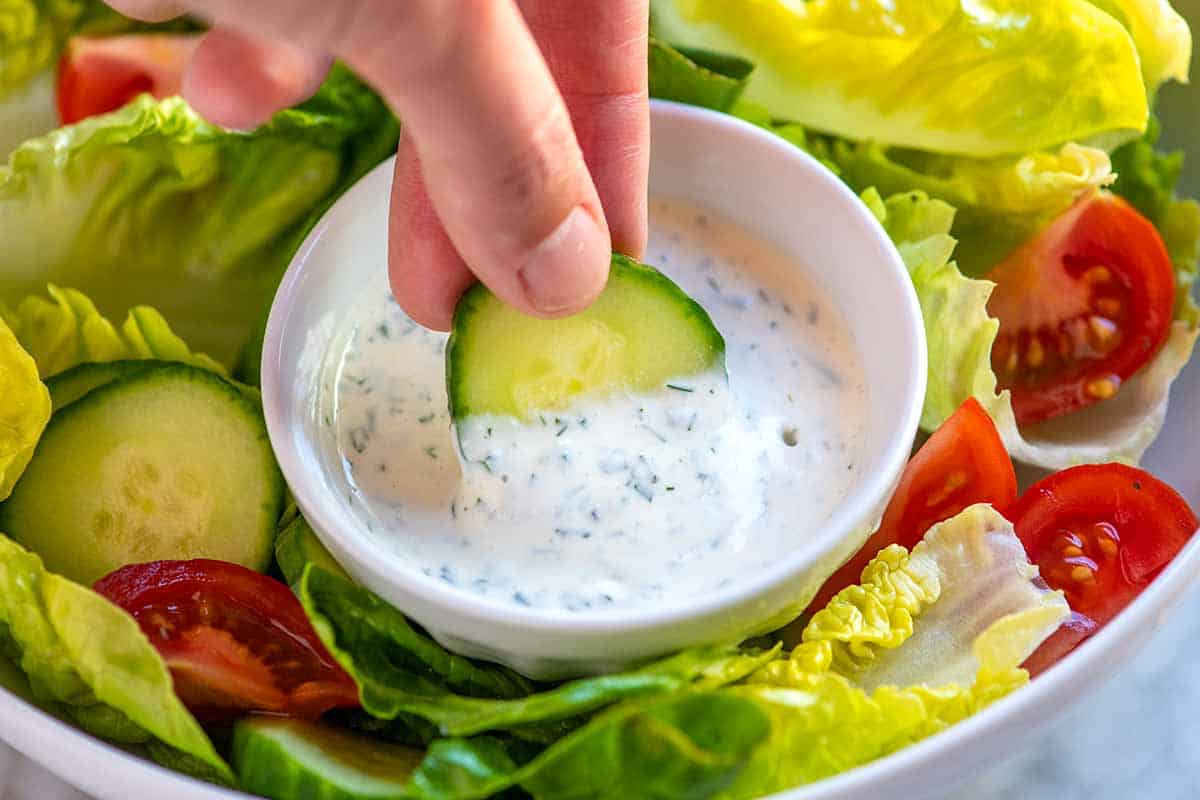 Dipping cucumber into homemade ranch dressing