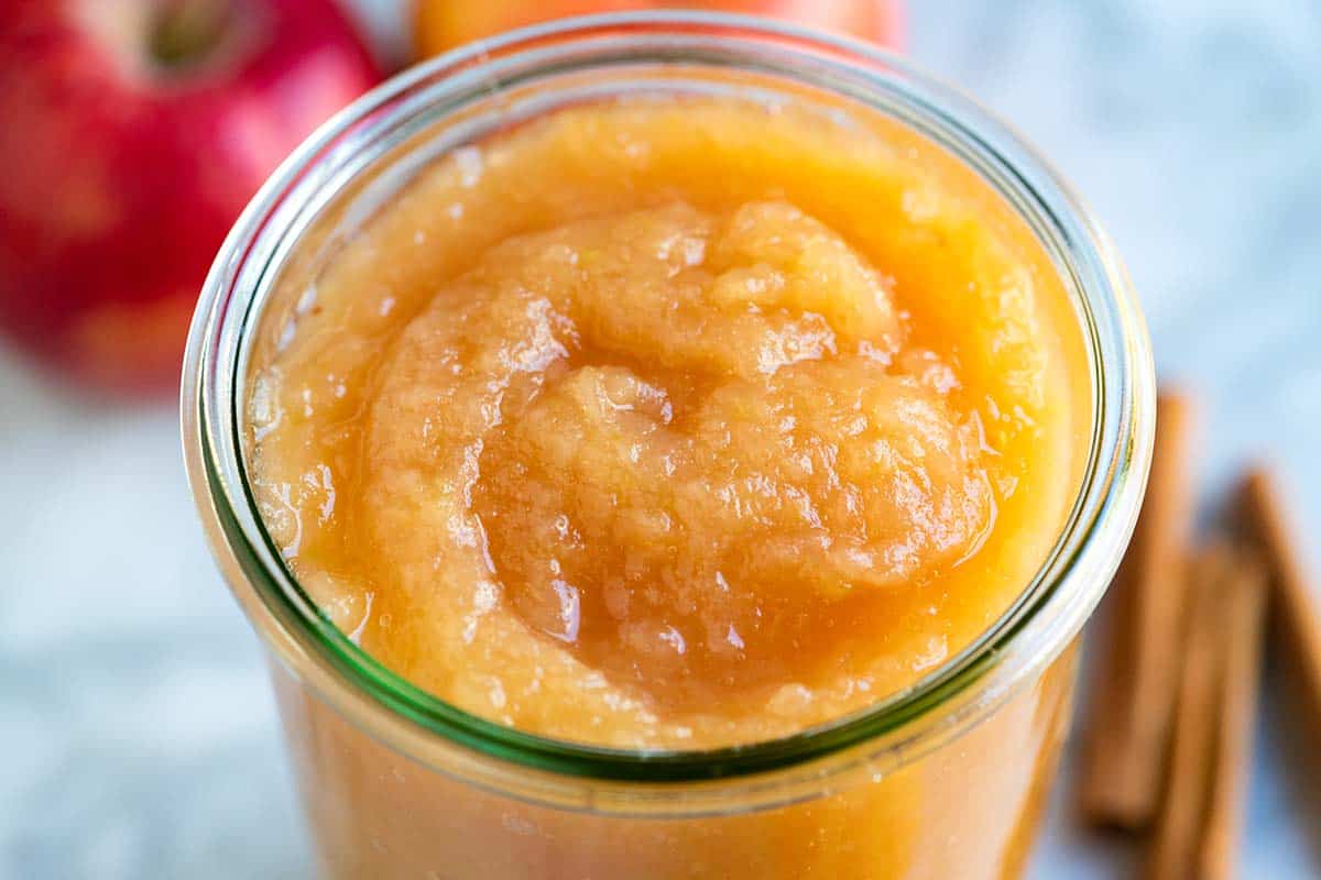 A jar of homemade applesauce made with apples and cinnamon.