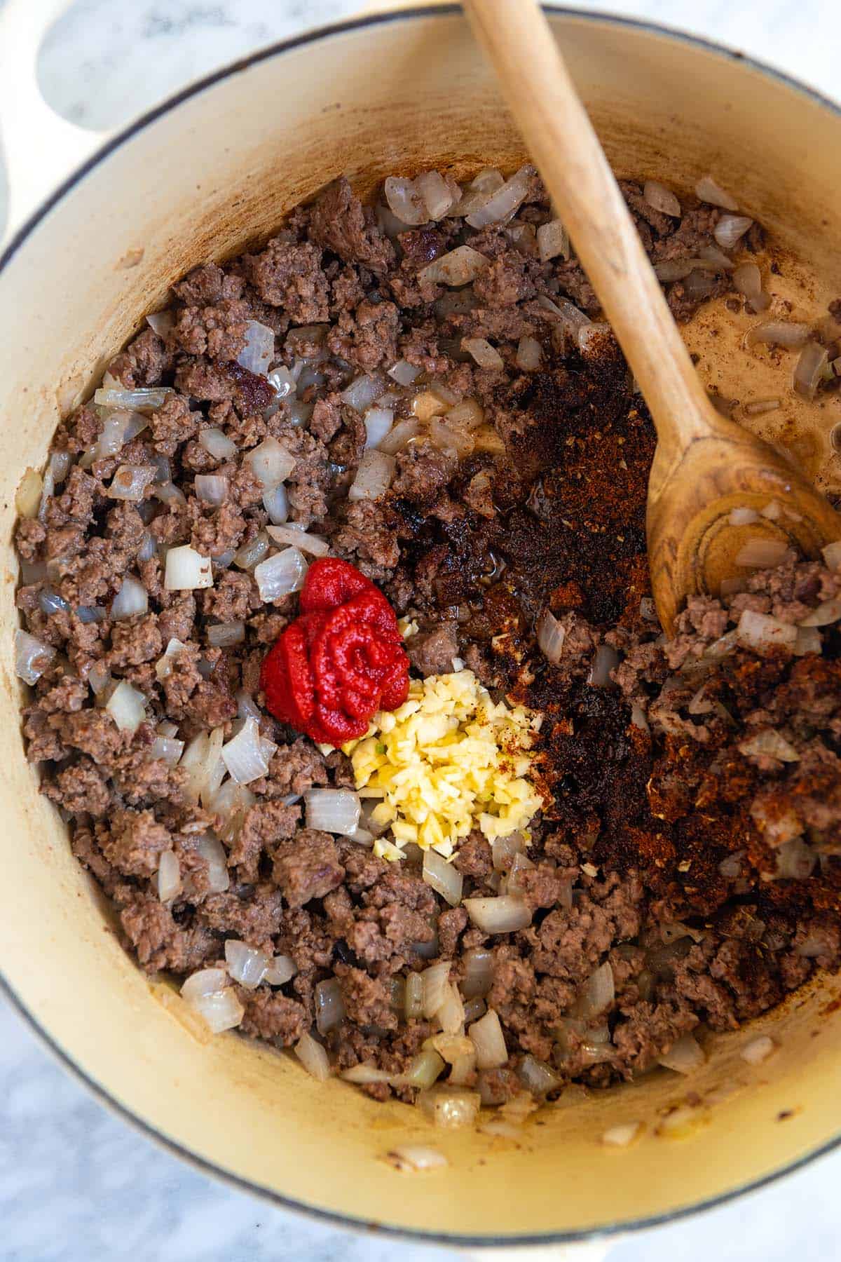 Making homemade chili with ground beef, onion, garlic and spices.