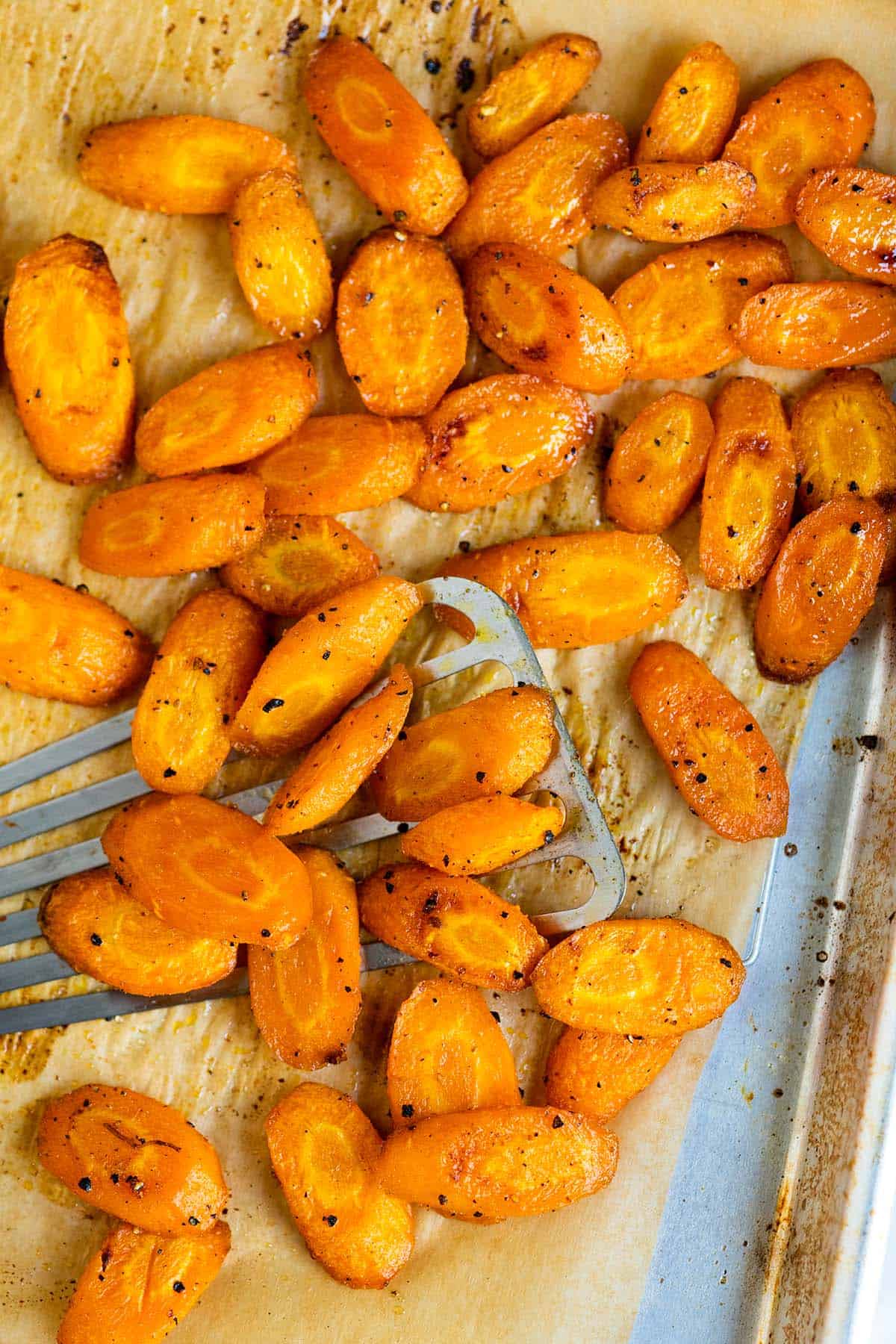 Perfectly roasted carrots on a baking sheet.