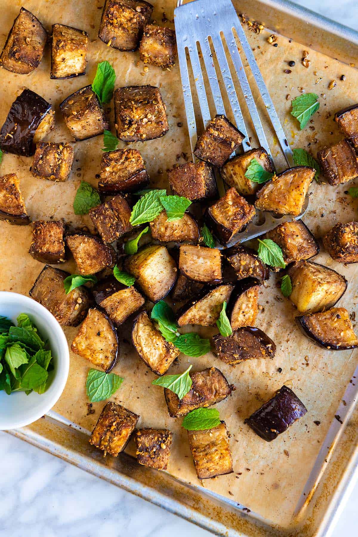 Perfectly roasted eggplant cubes on a baking sheet