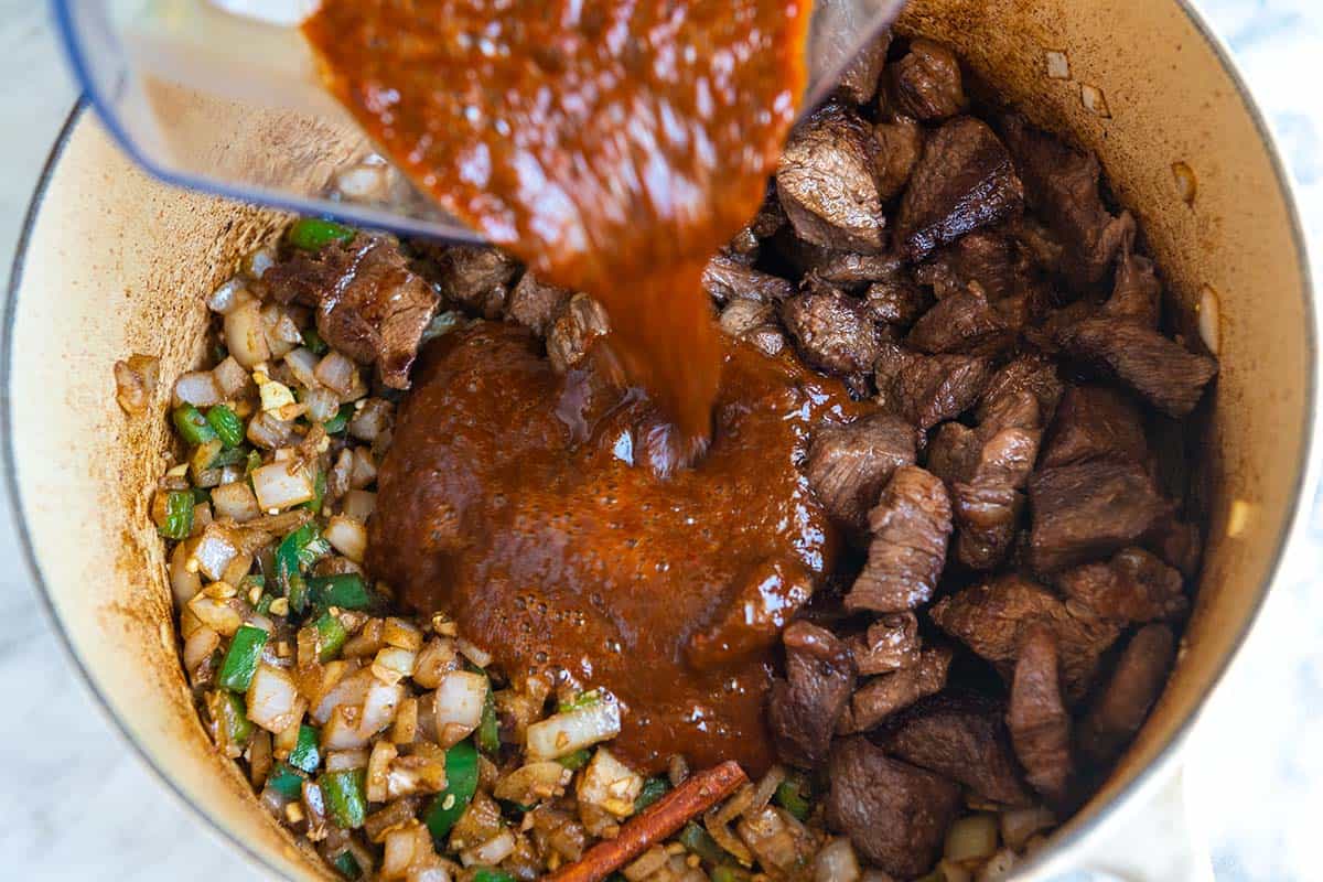 Adding all the chili ingredients to the pot