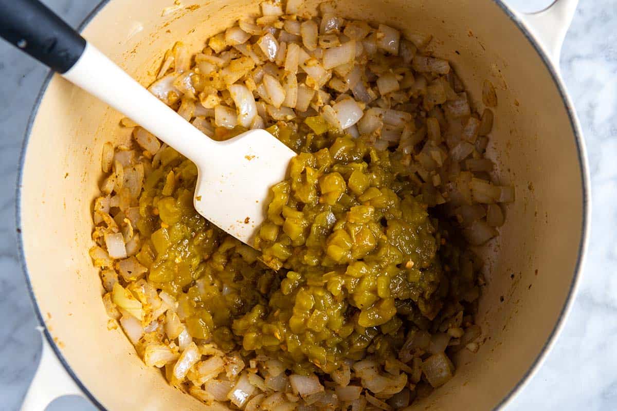 Adding canned green chilies to the pot for white chicken chili