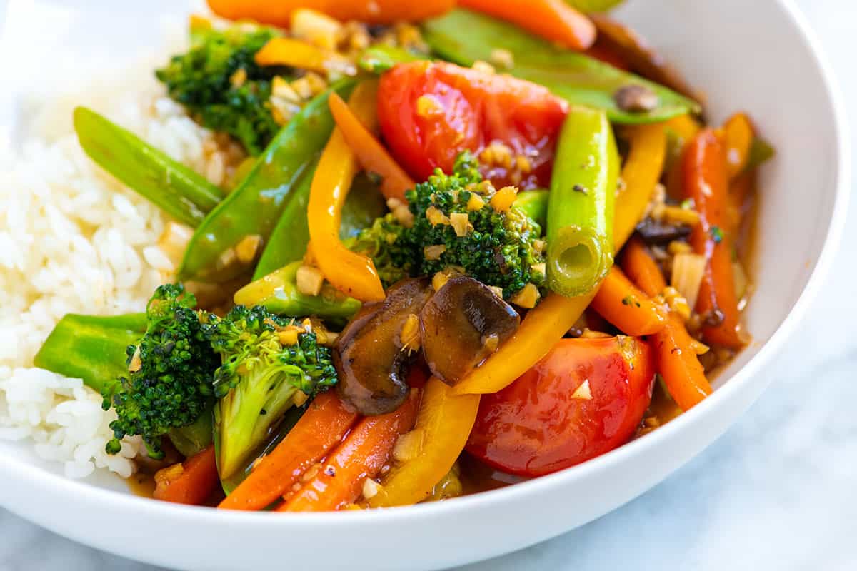 Garlic Ginger Veggie Stir Fry with broccoli, tomatoes, bell pepper, carrots, and a homemade stir fry sauce.