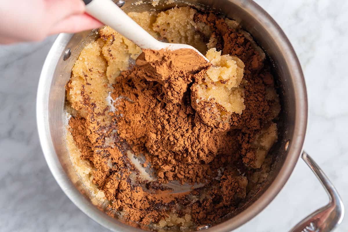 Stirring cocoa powder into sugar and butter for brownies with shiny tops and chewy edges