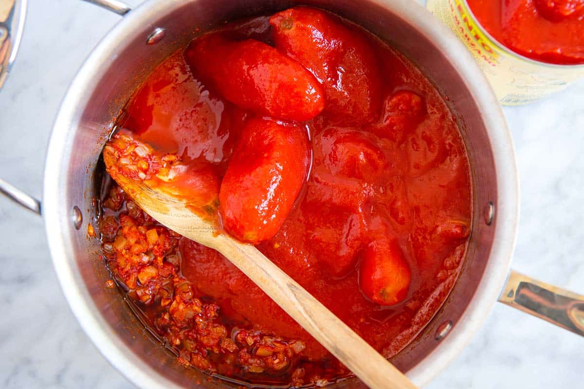 Whole peeled tomatoes in a pot for pasta sauce