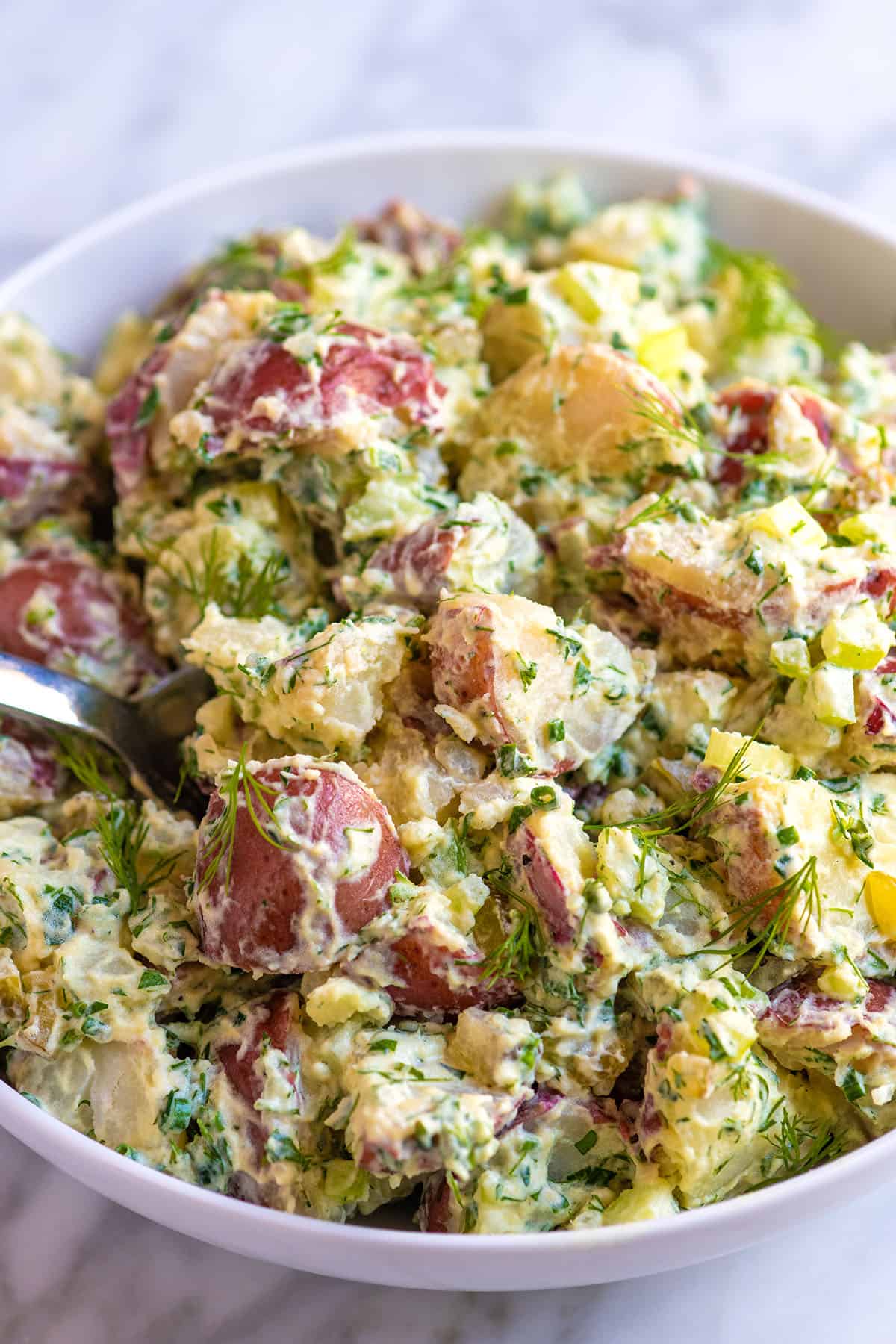 A bowl of red potato salad made with a creamy dressing