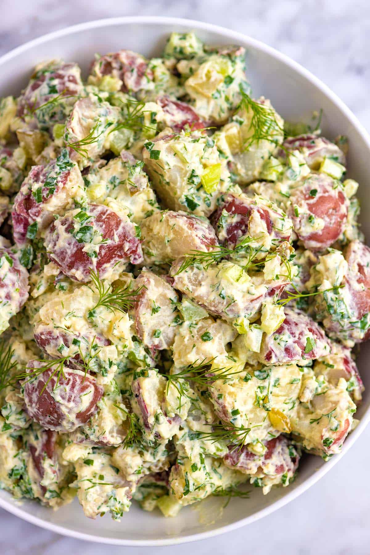 A bowl of red potato salad tossed in a creamy dressing