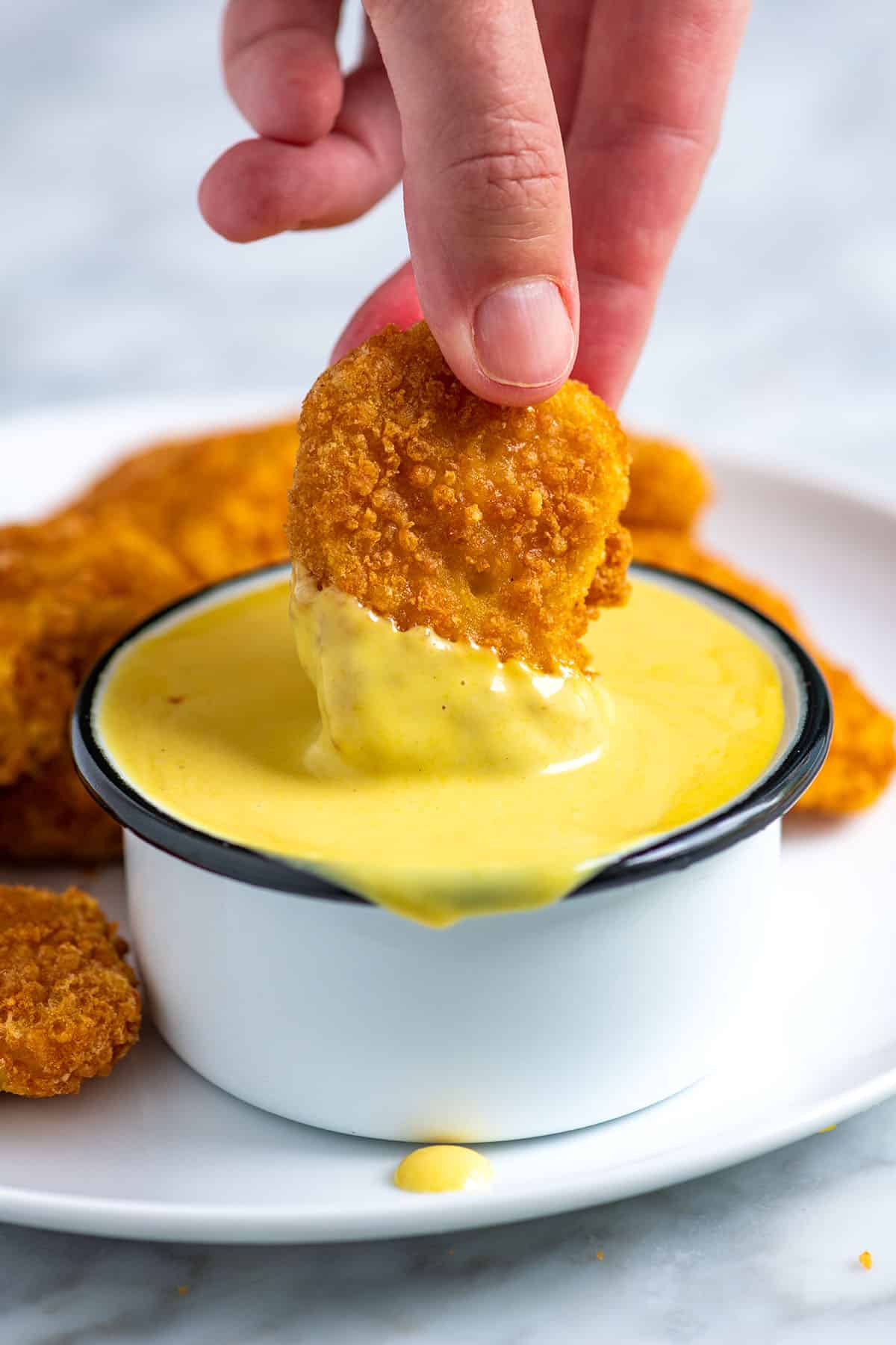 Dipping chicken nugget into homemade honey mustard sauce