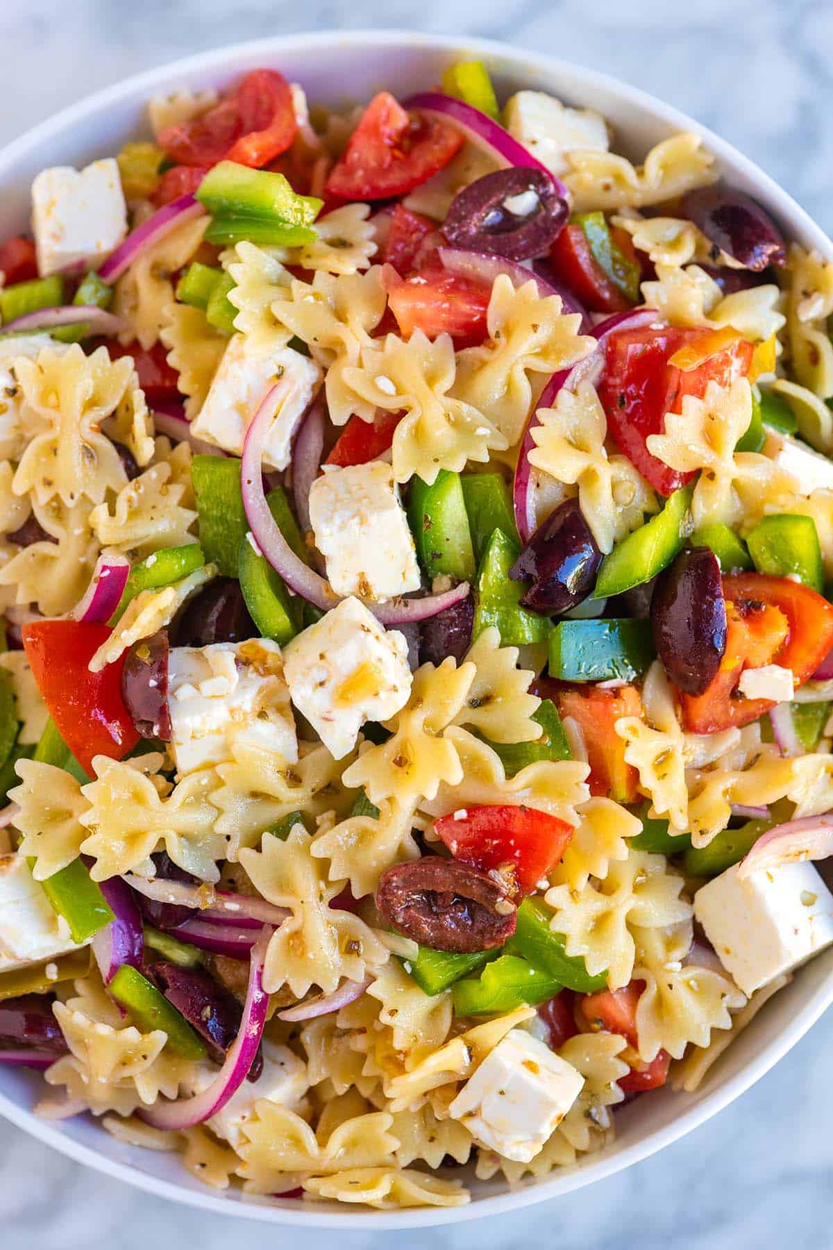Greek Pasta Salad with feta, olives, tomatoes, and red onion.
